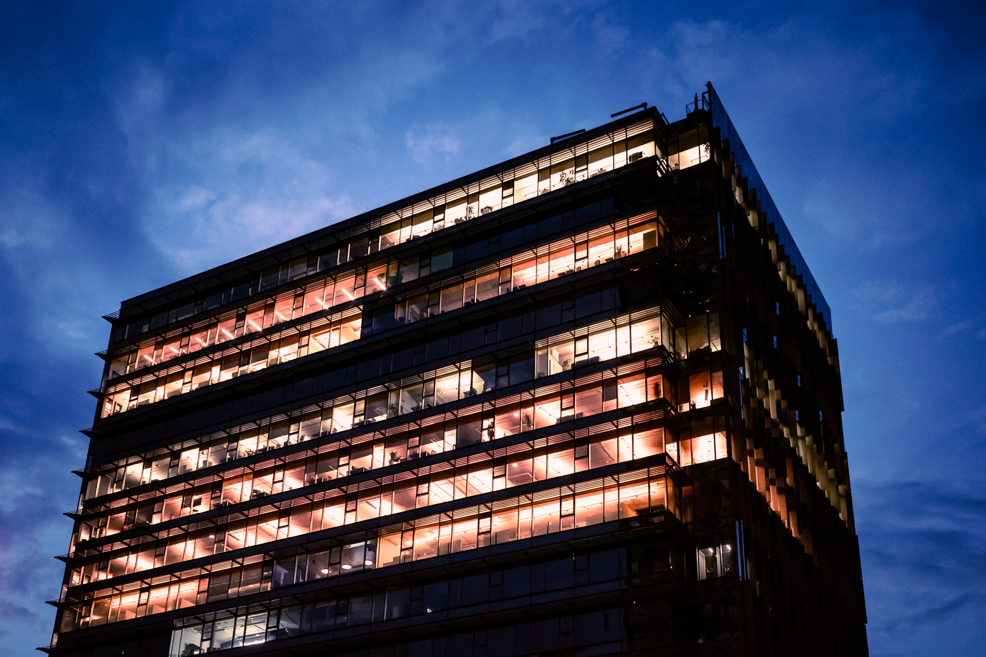 Modern kantoorgebouw met verlichte verdiepingen in de avond