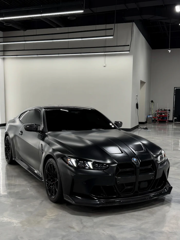 Matte black sports car in a garage