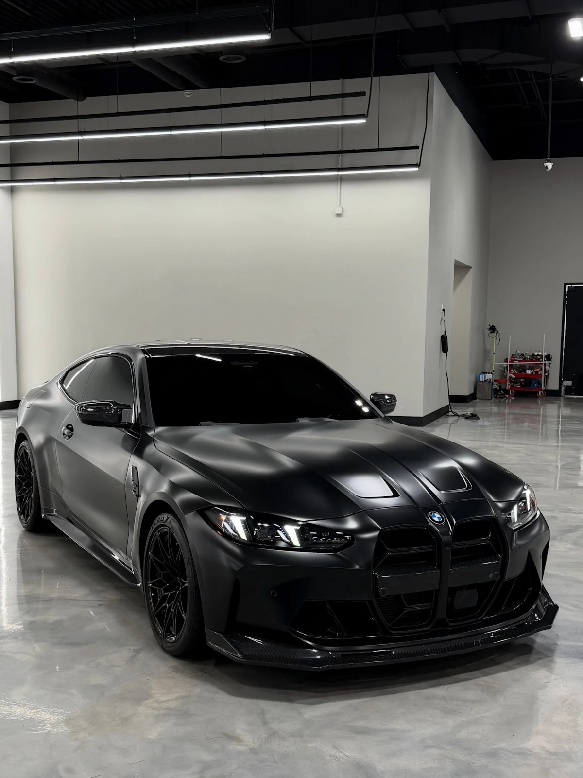Matte black sports car parked on a polished concrete floor