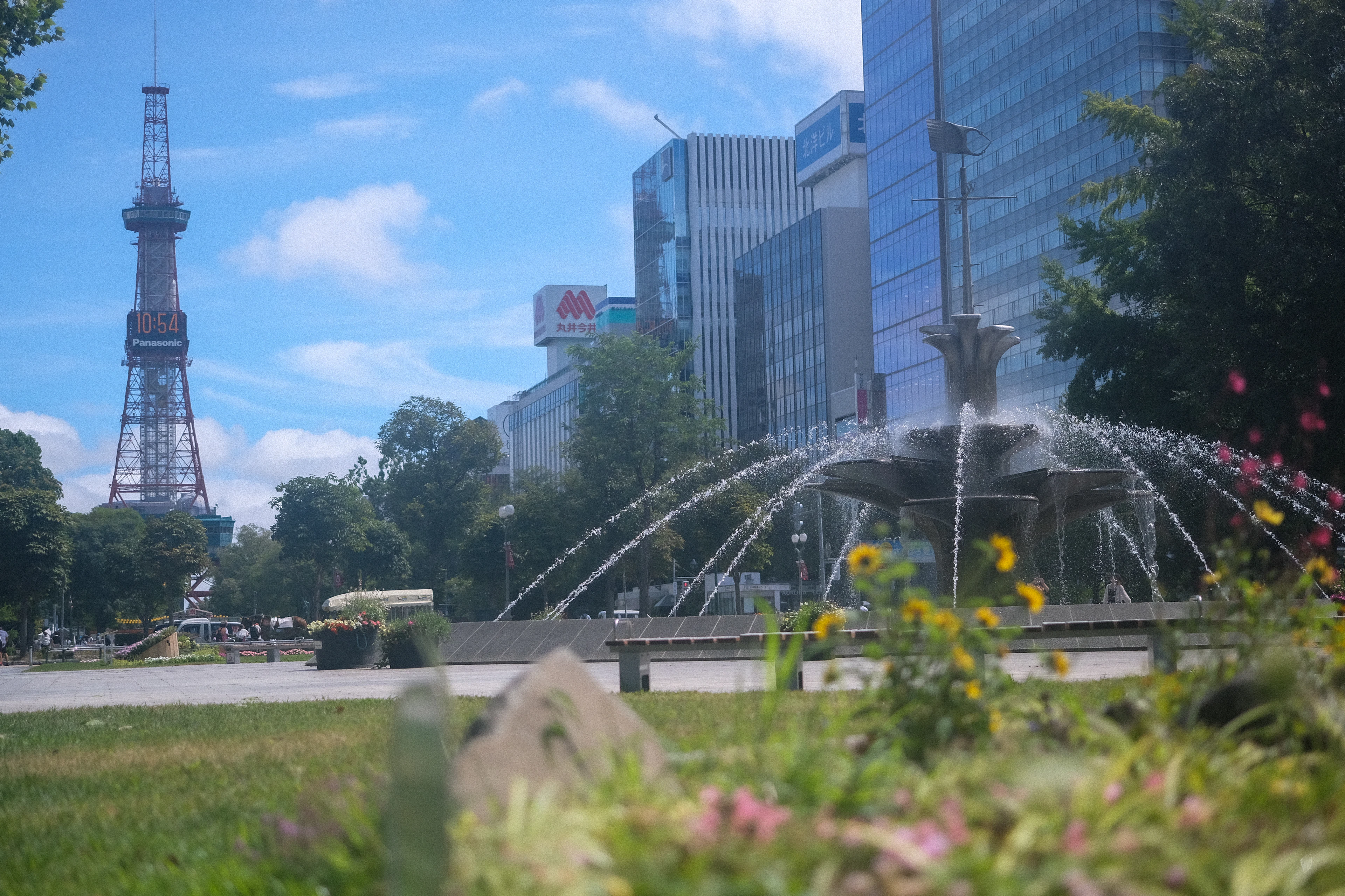 The Sapporo TV Tower rising beyond the fountain of Odori Park on a summer day in Sapporo, Japan
