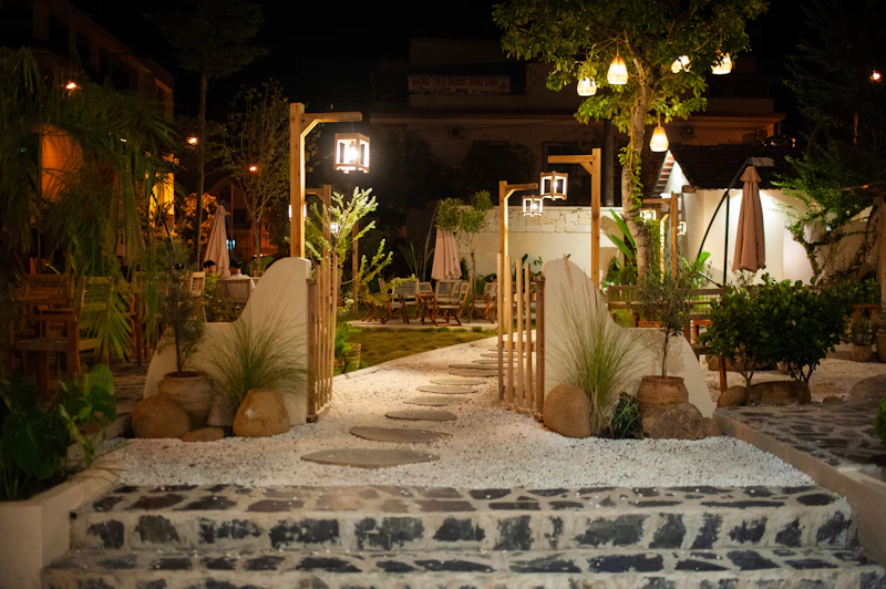Stone garden terrace with warm landscape lighting and lanterns at dusk