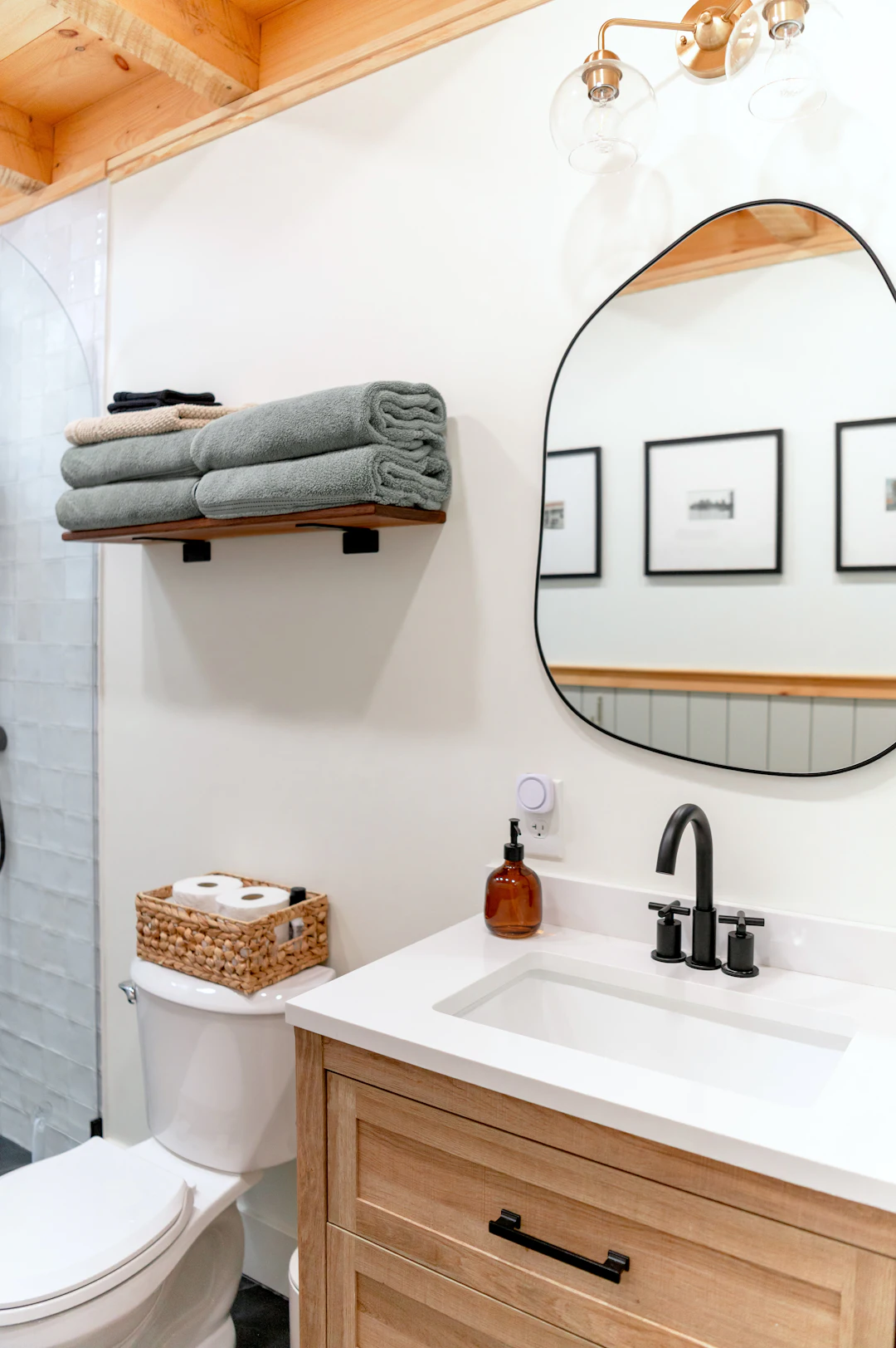 A bathroom with a wooden vanity and a white basin