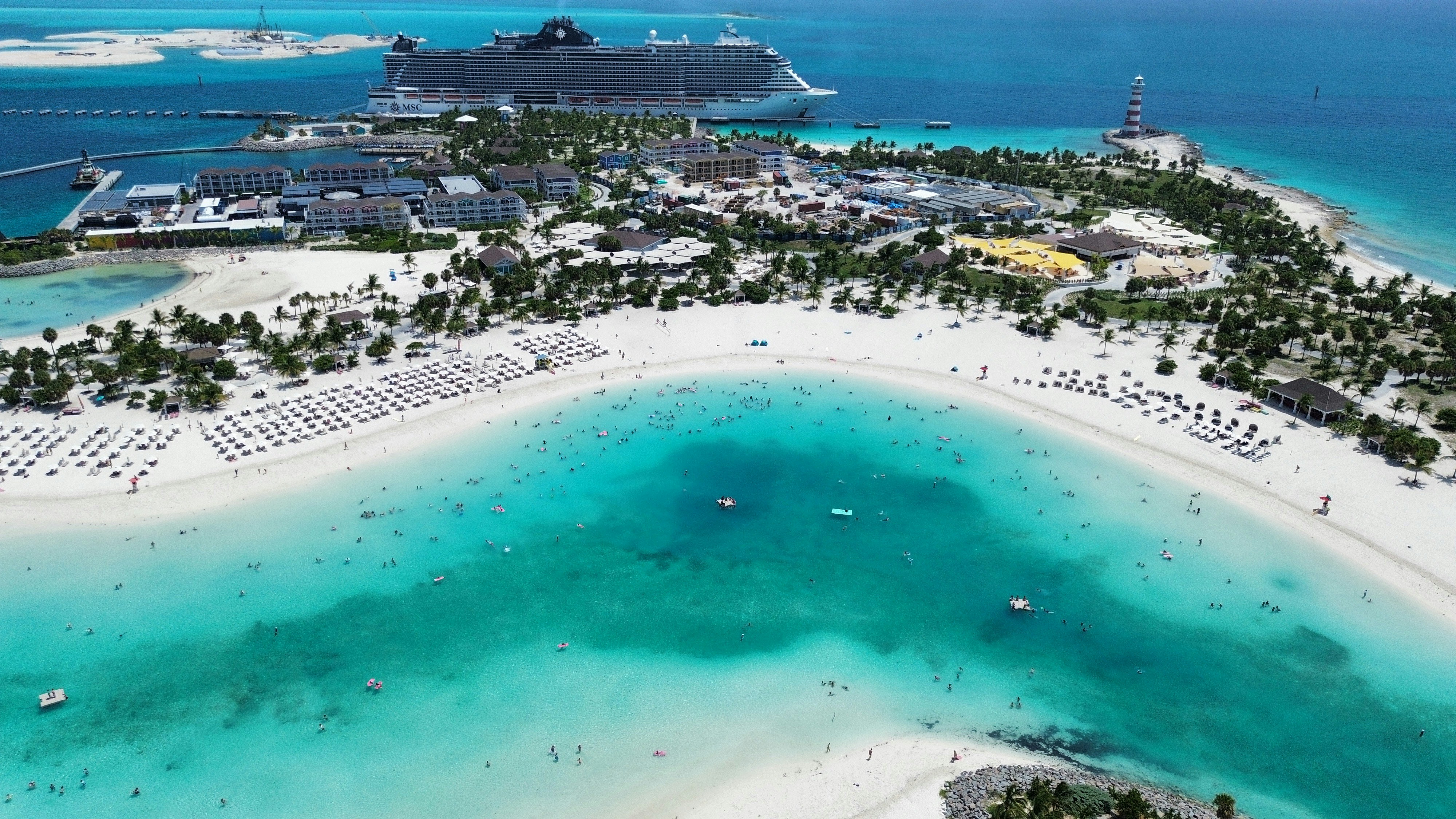 Aerial view of a cruise ship docked at a tropical island beach resort