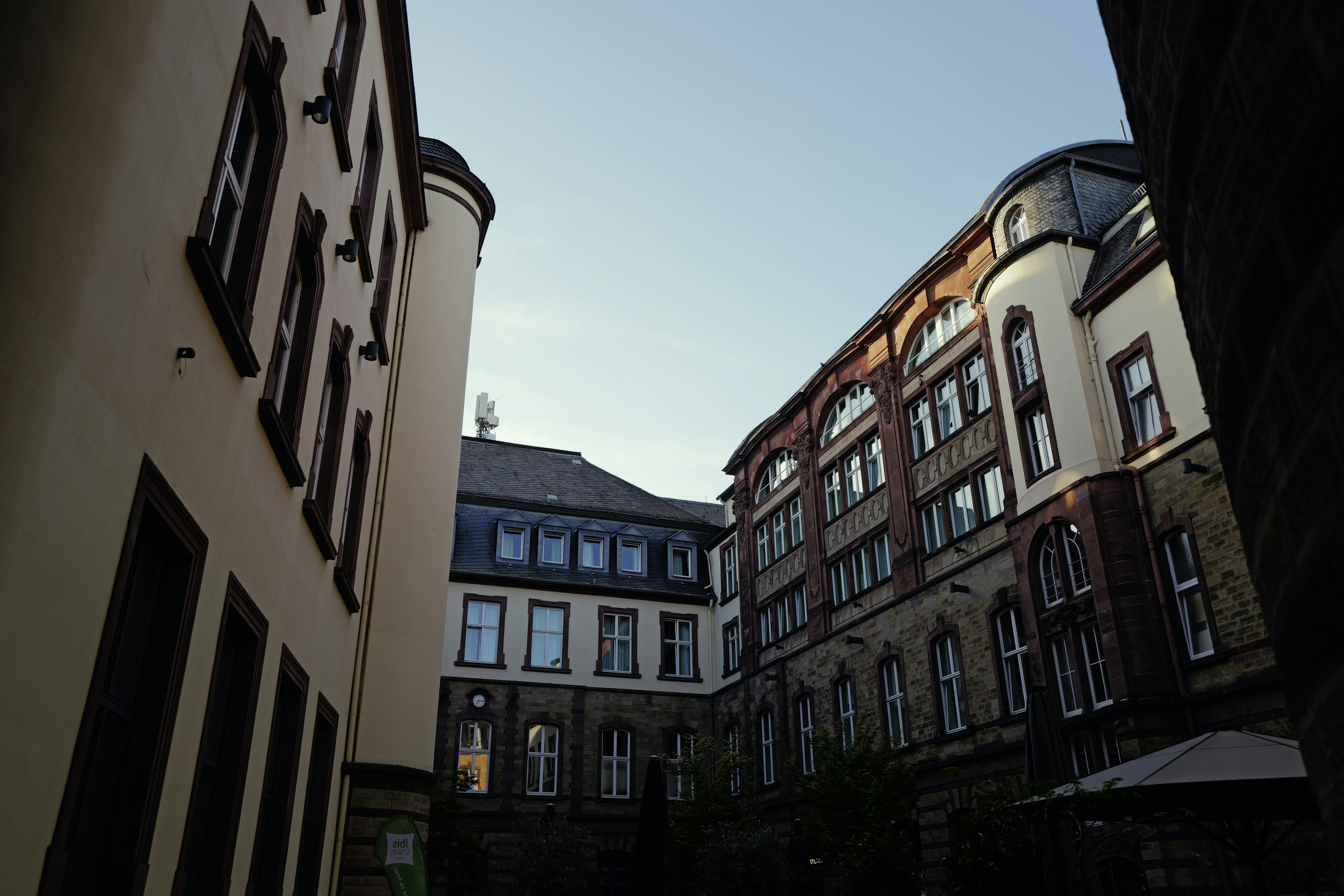A courtyard surrounded by historic stone and stucco buildings with many windows