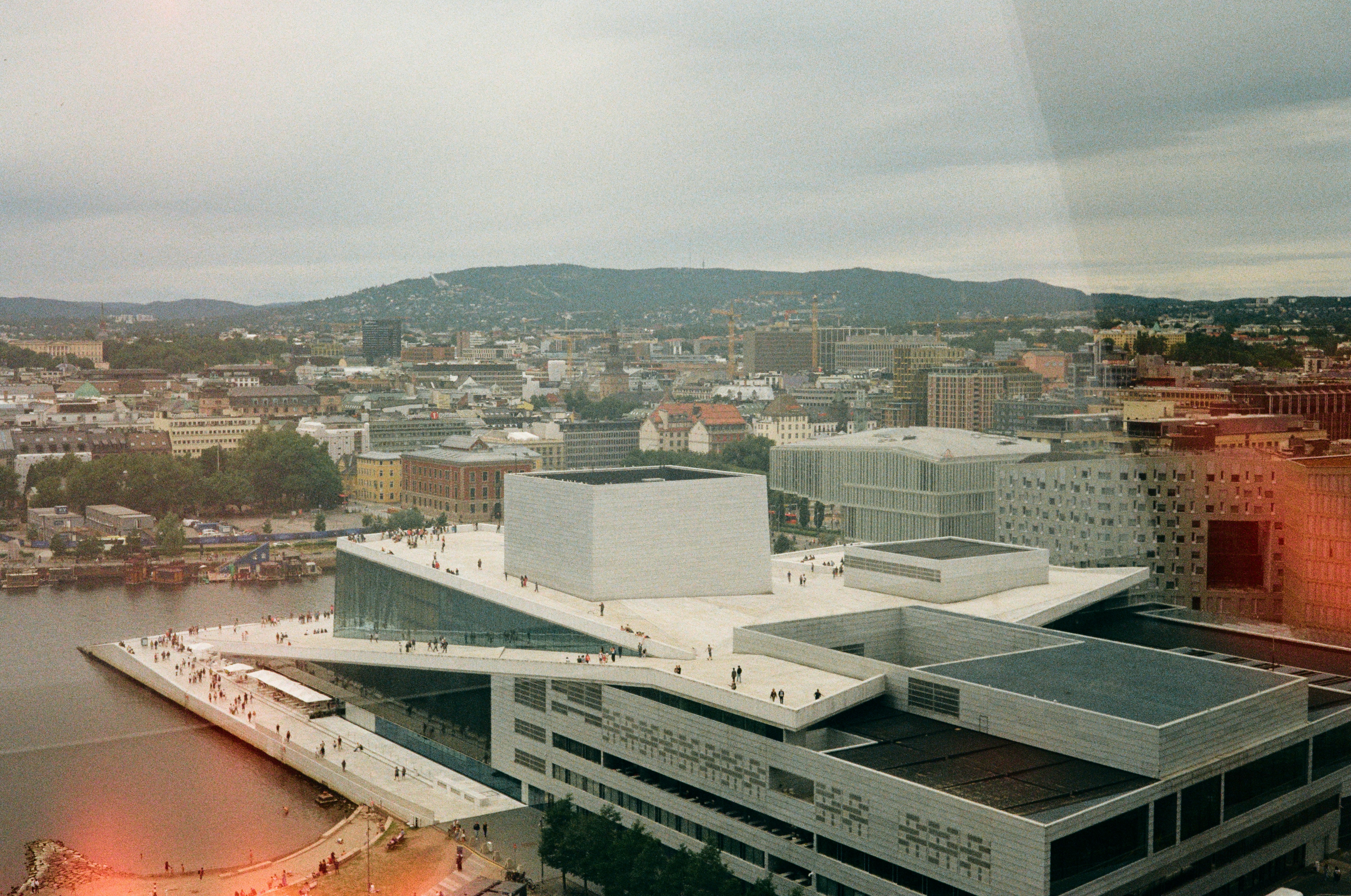 The Oslo Opera House with people walking on its white marble roof in Oslo