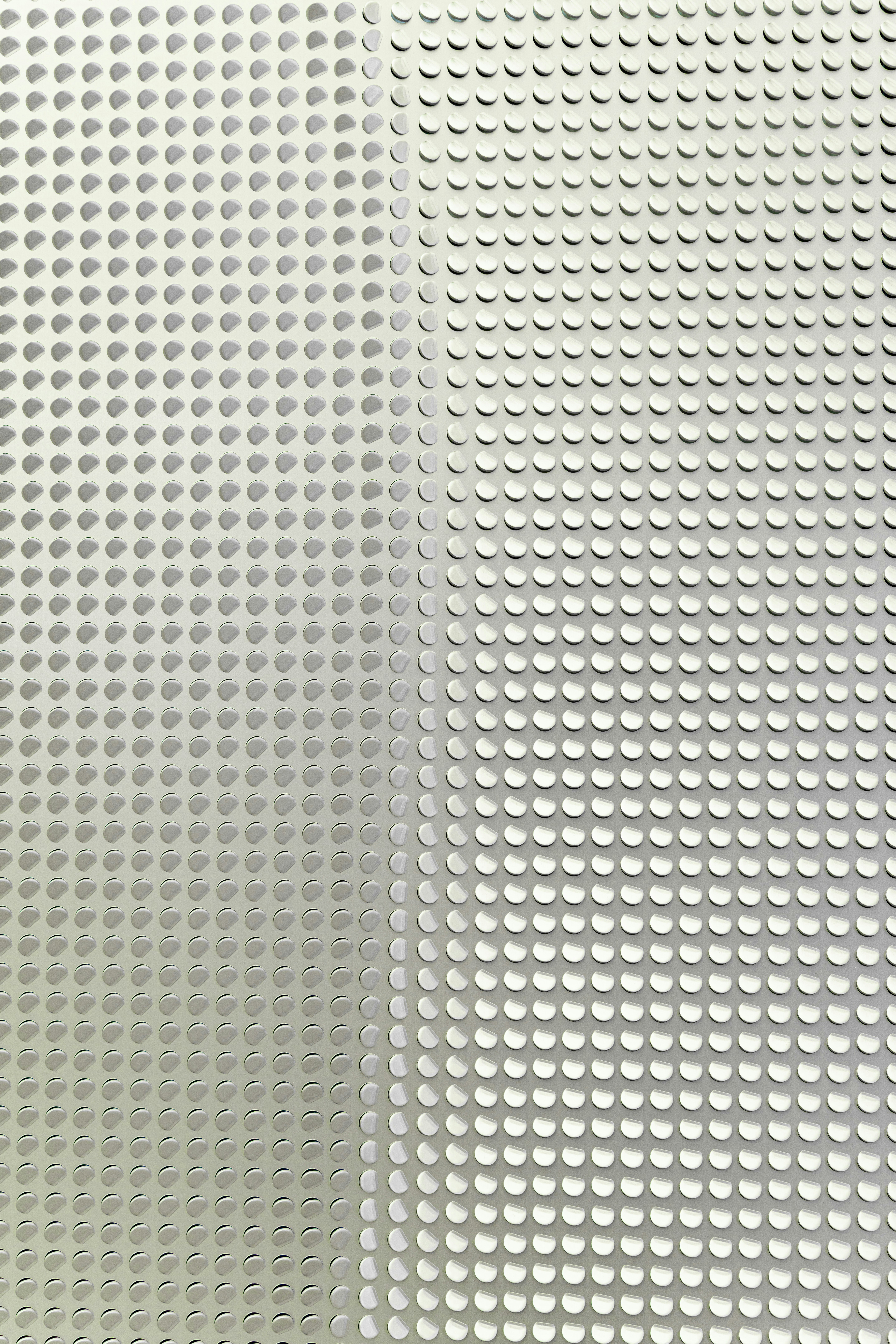 A grid of raised white circular dots on a light grey surface