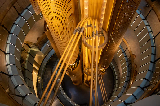 A high-angle view of a spiral staircase surrounding a central yellow industrial column