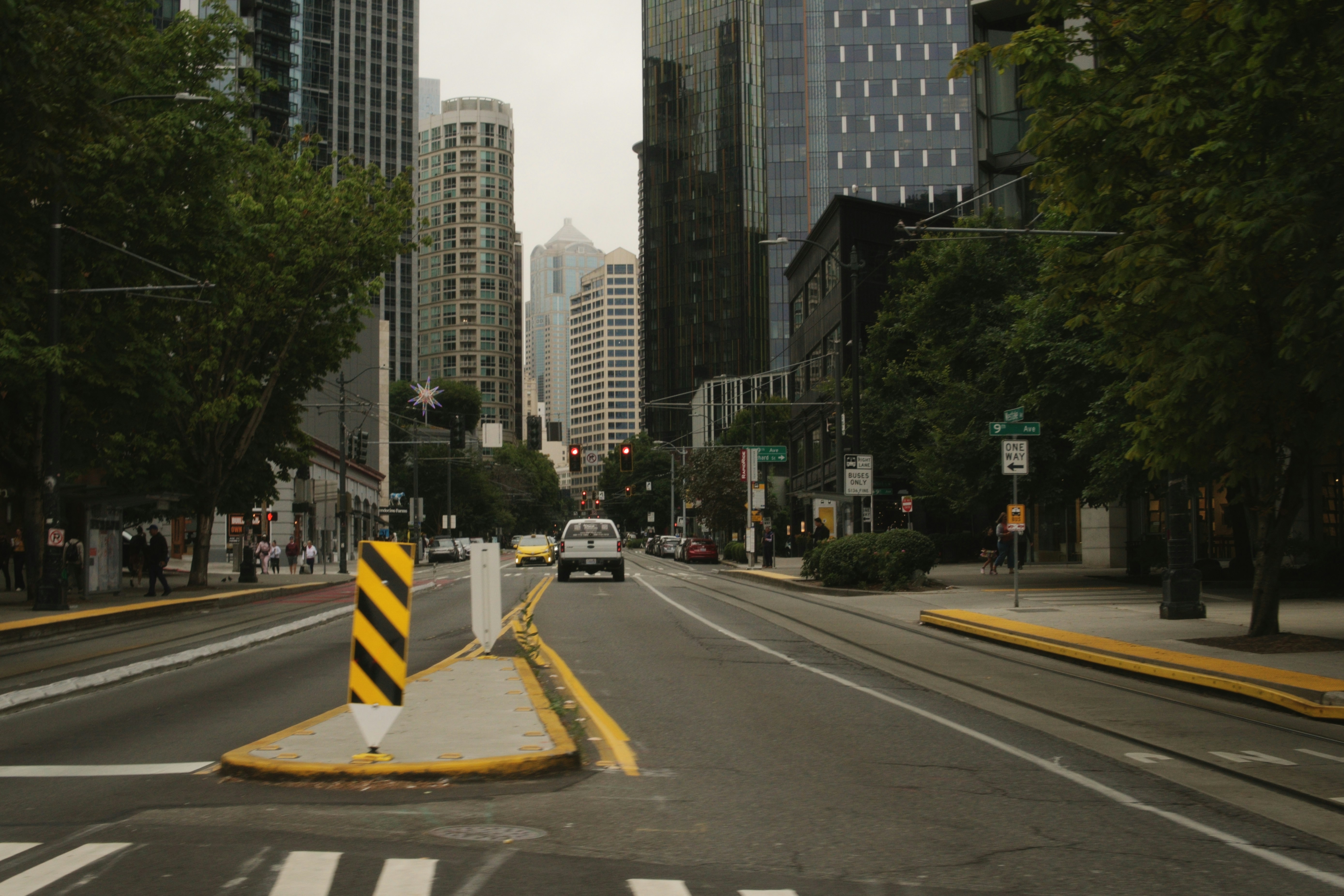 A street in Seattle with tall glass skyscrapers and a white pickup truck