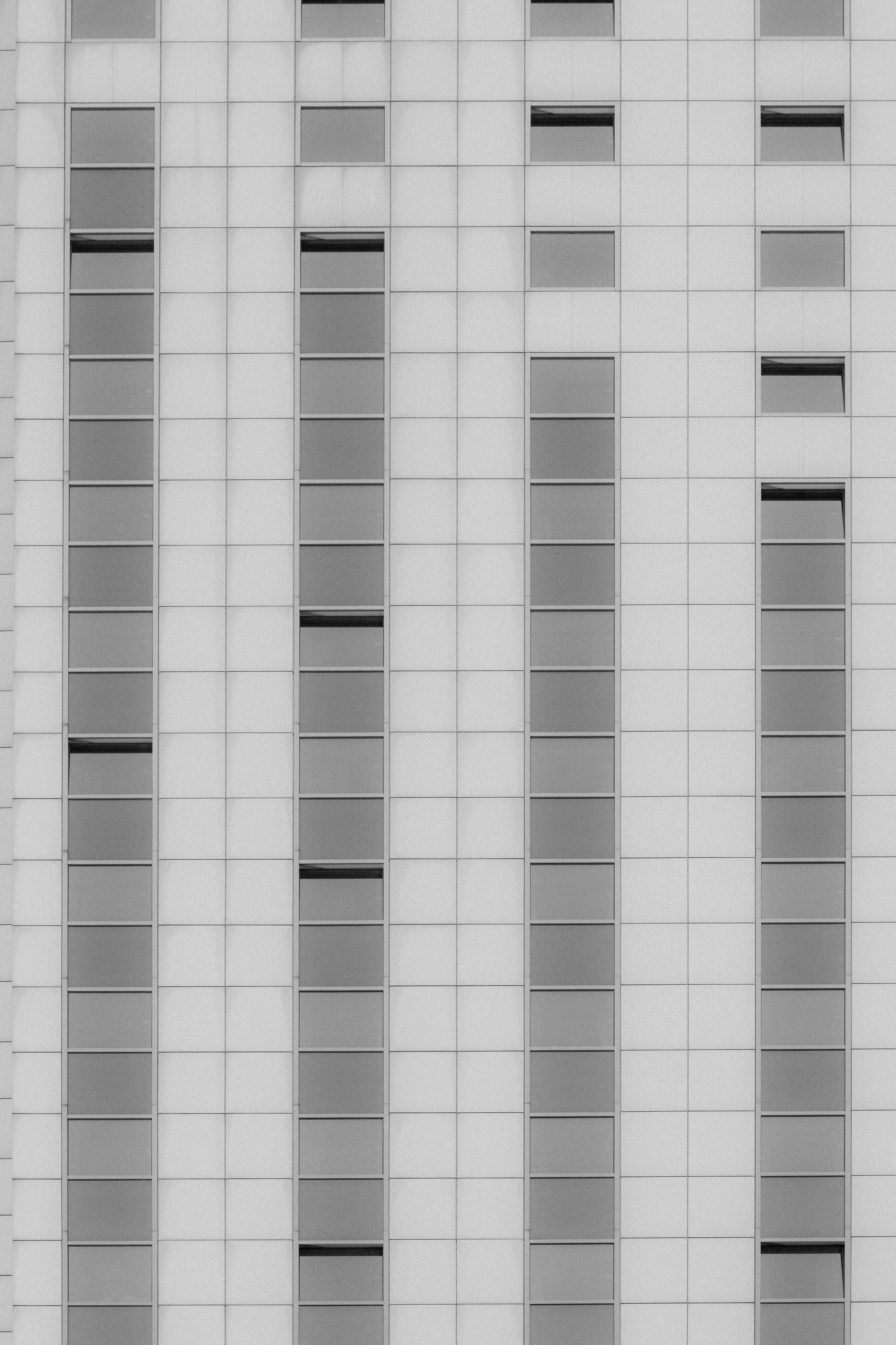 A grid of rectangular windows on a white tiled building facade - 相关推荐