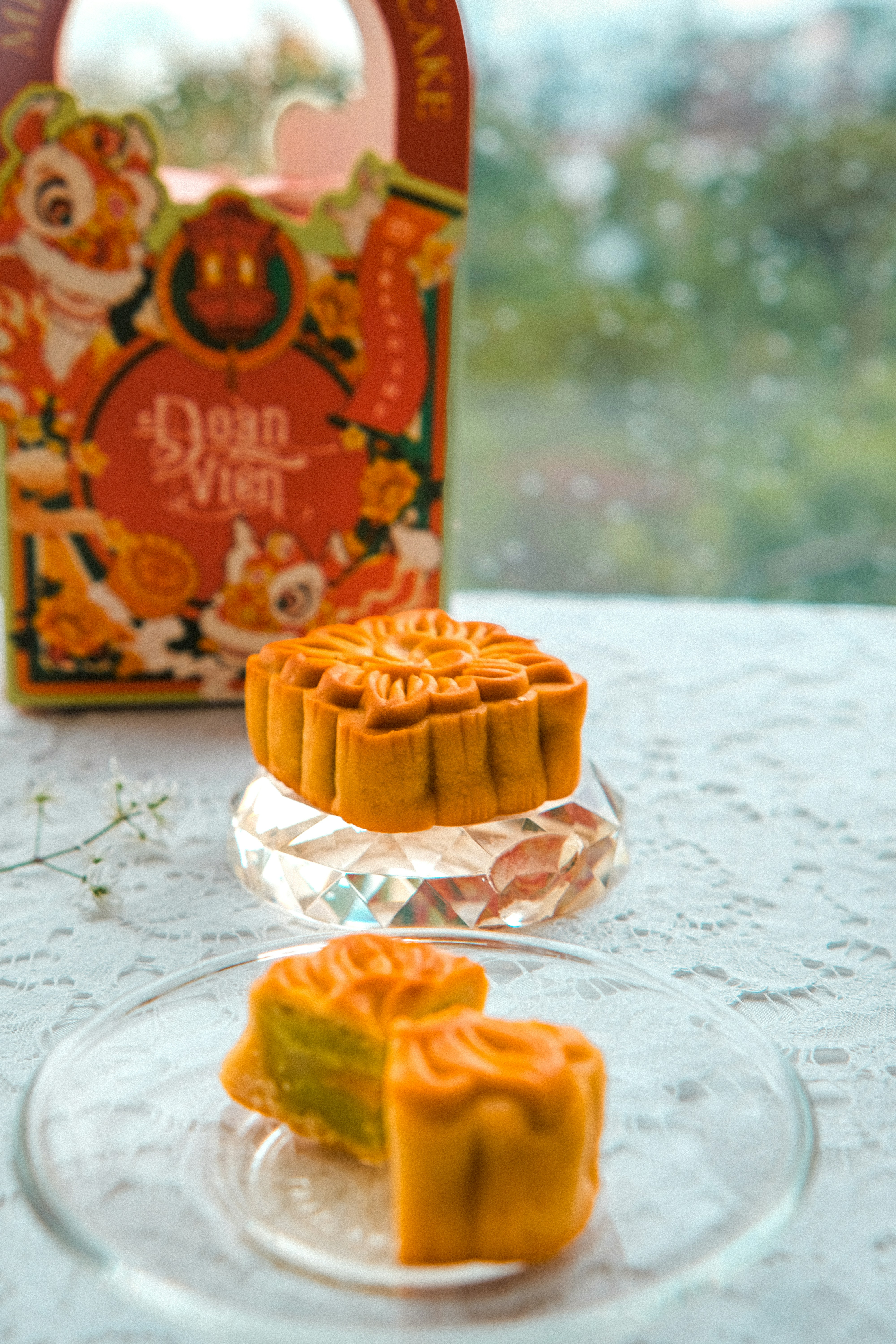 Mooncakes on a glass plate with a decorative gift box in the background