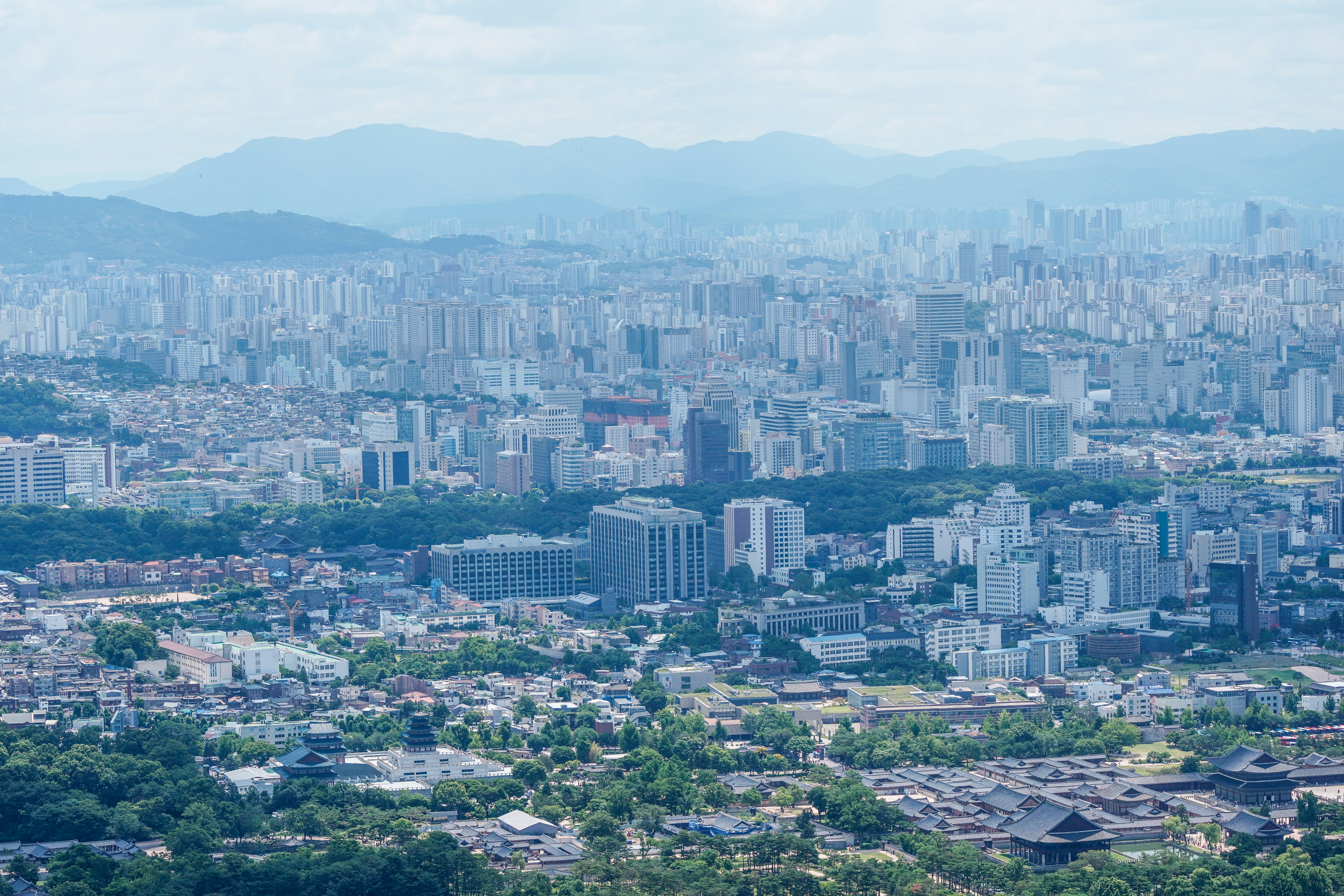 Aerial view of Gyeongbokgung Palace and the dense modern skyline of Seoul