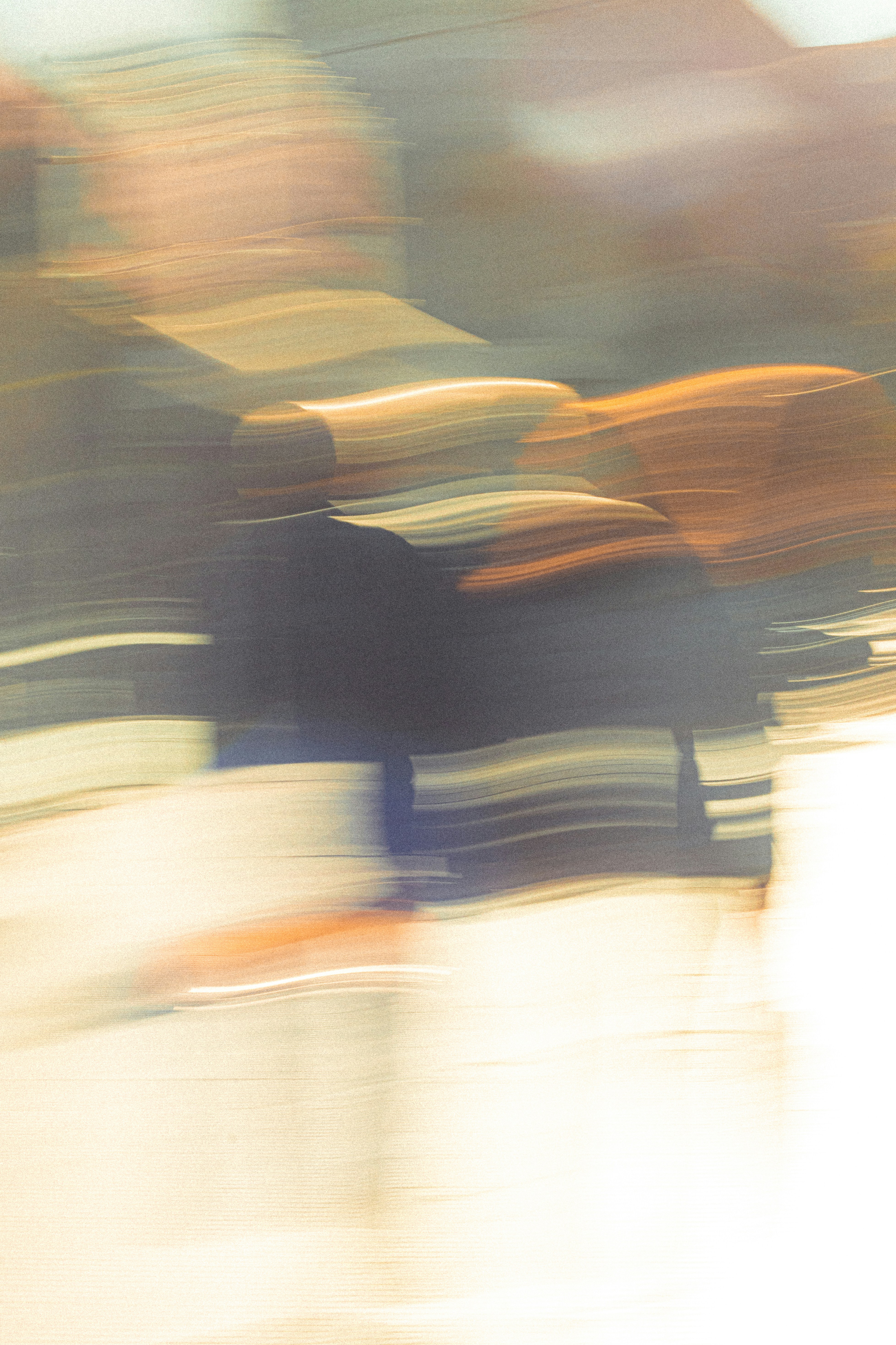 A person in motion creating a long exposure blur of orange and dark shapes