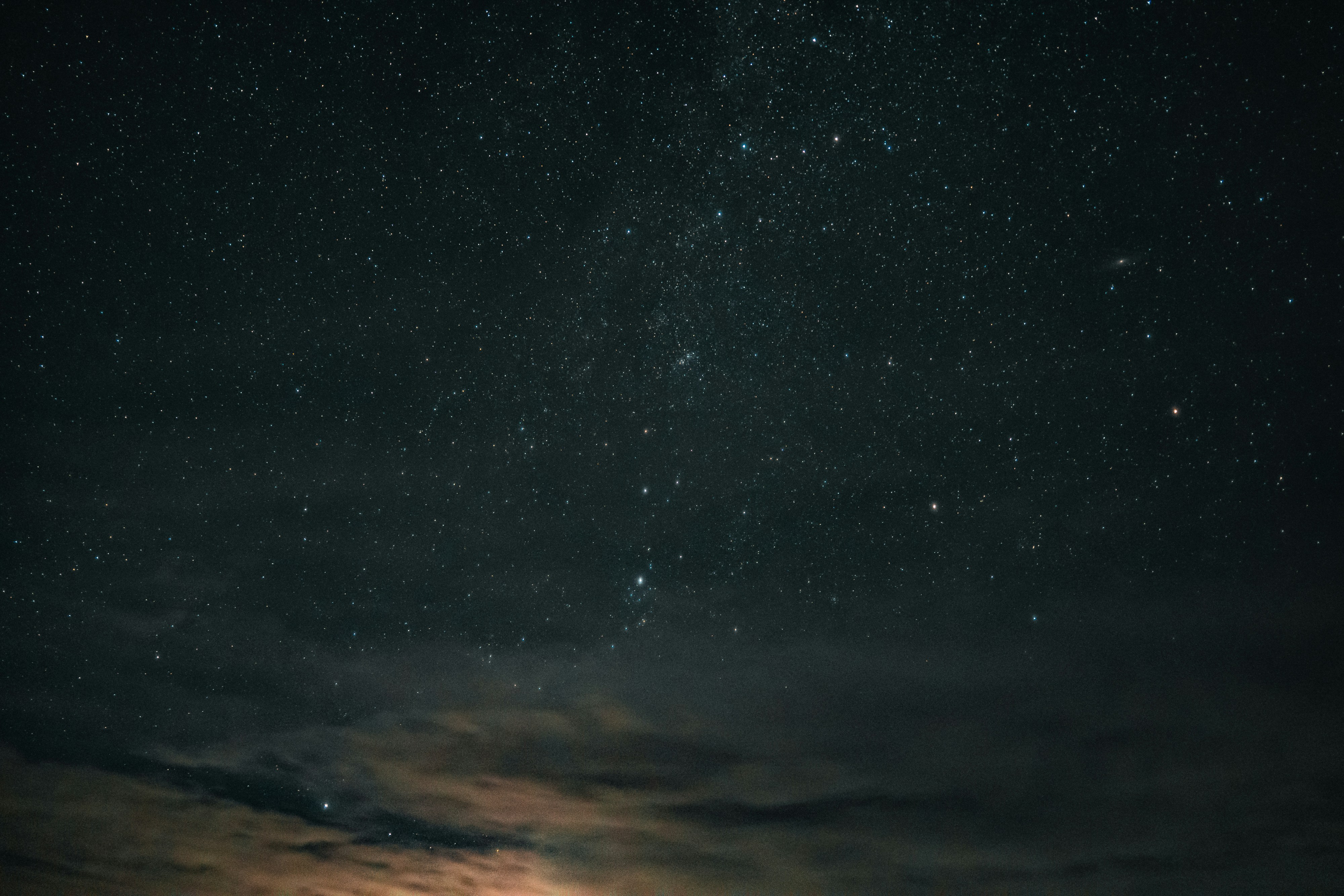 A vast night sky filled with countless stars above dark clouds