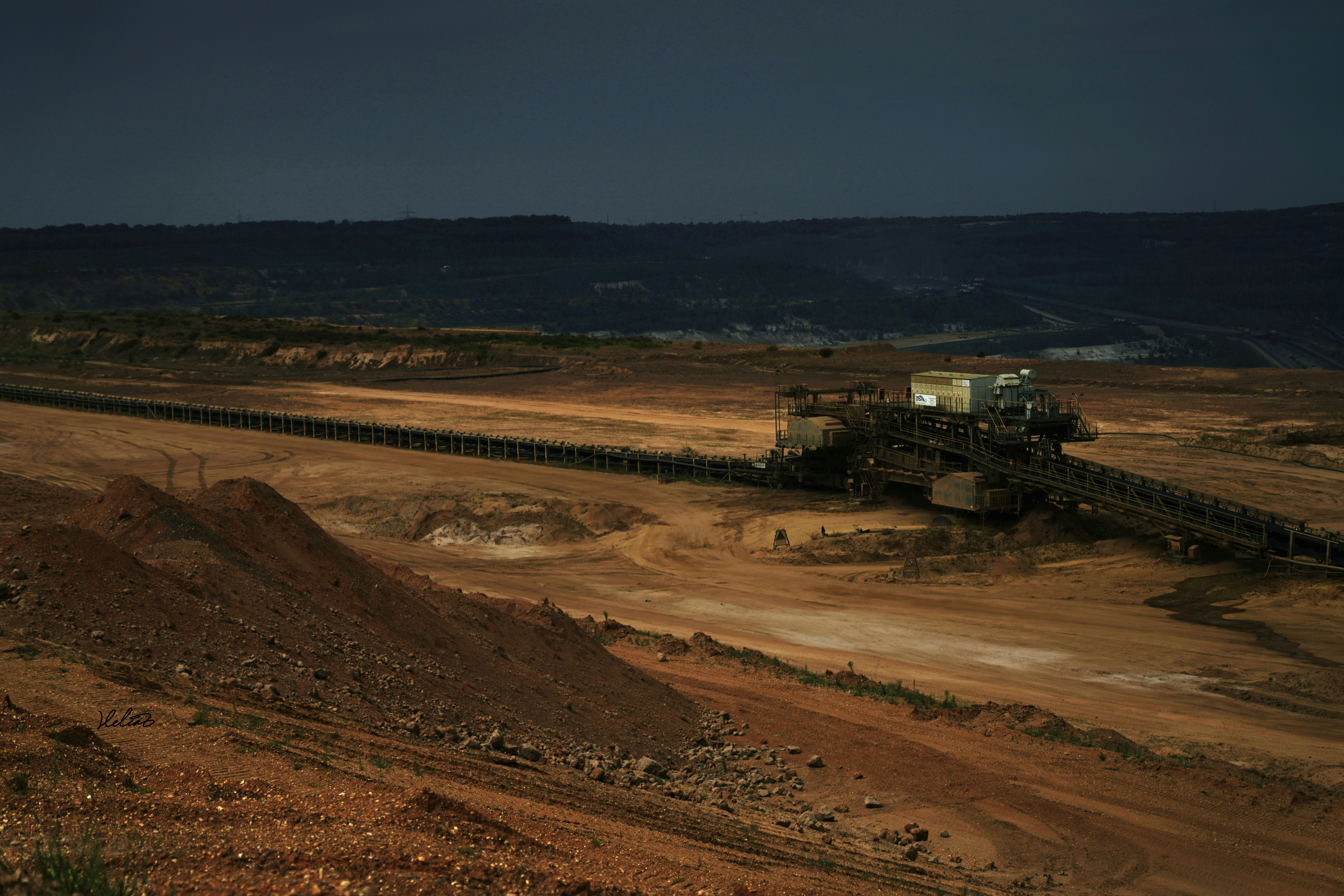 A long conveyor carrying ore across an open-pit mine