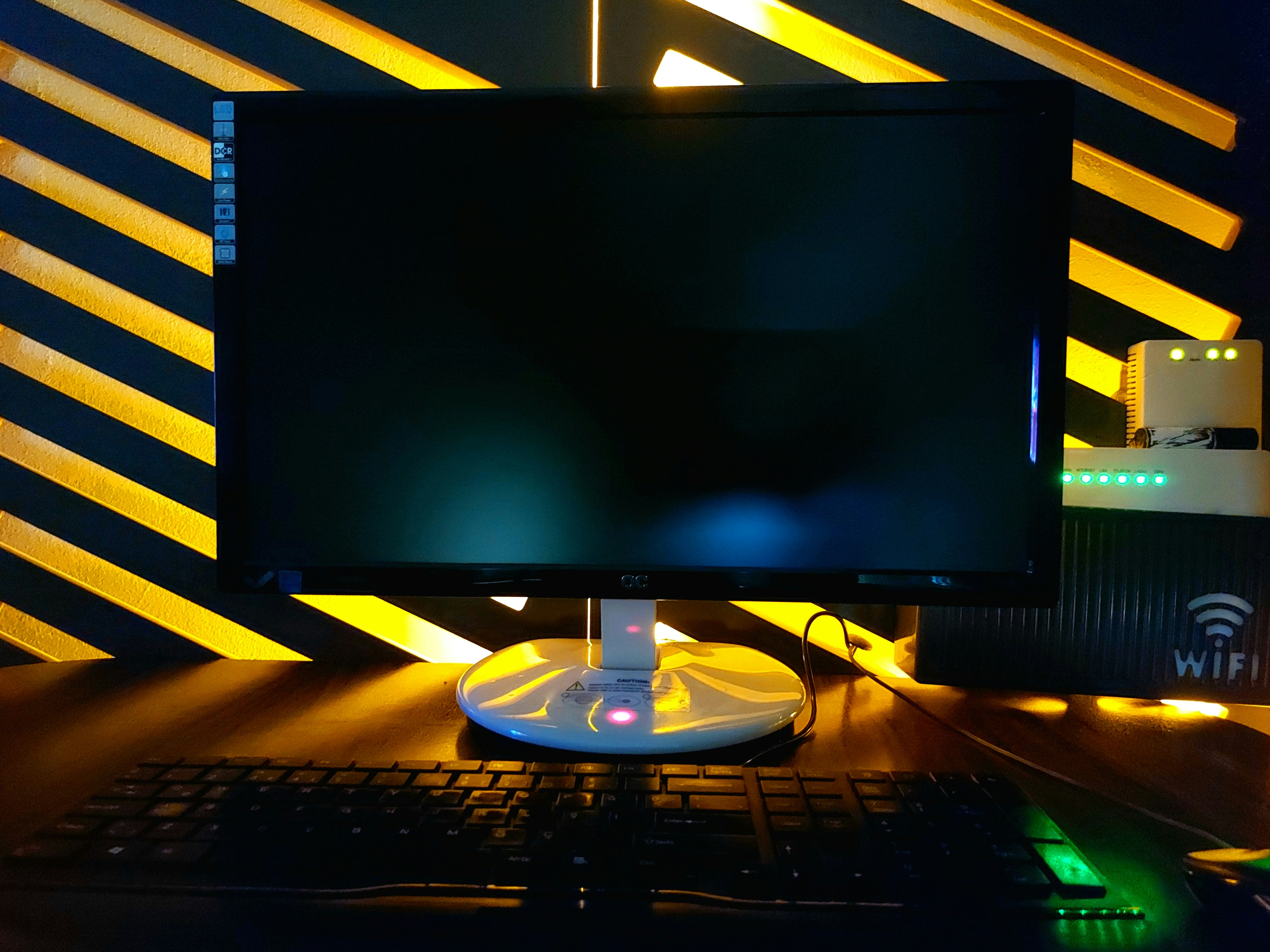 A computer monitor and keyboard on a desk with a yellow striped background