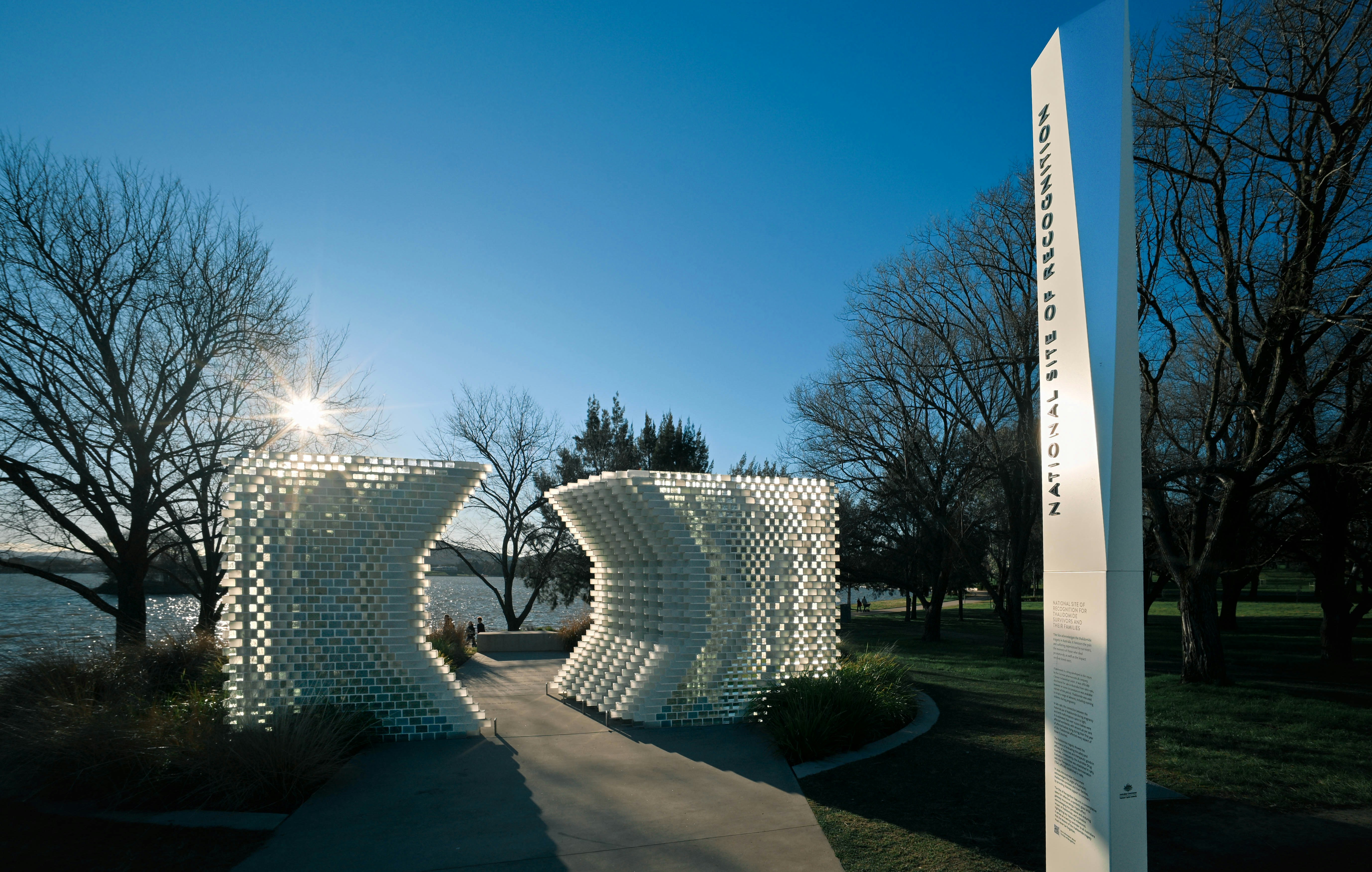 The National Site of Recognition sculpture in Canberra with a tall sign and trees
