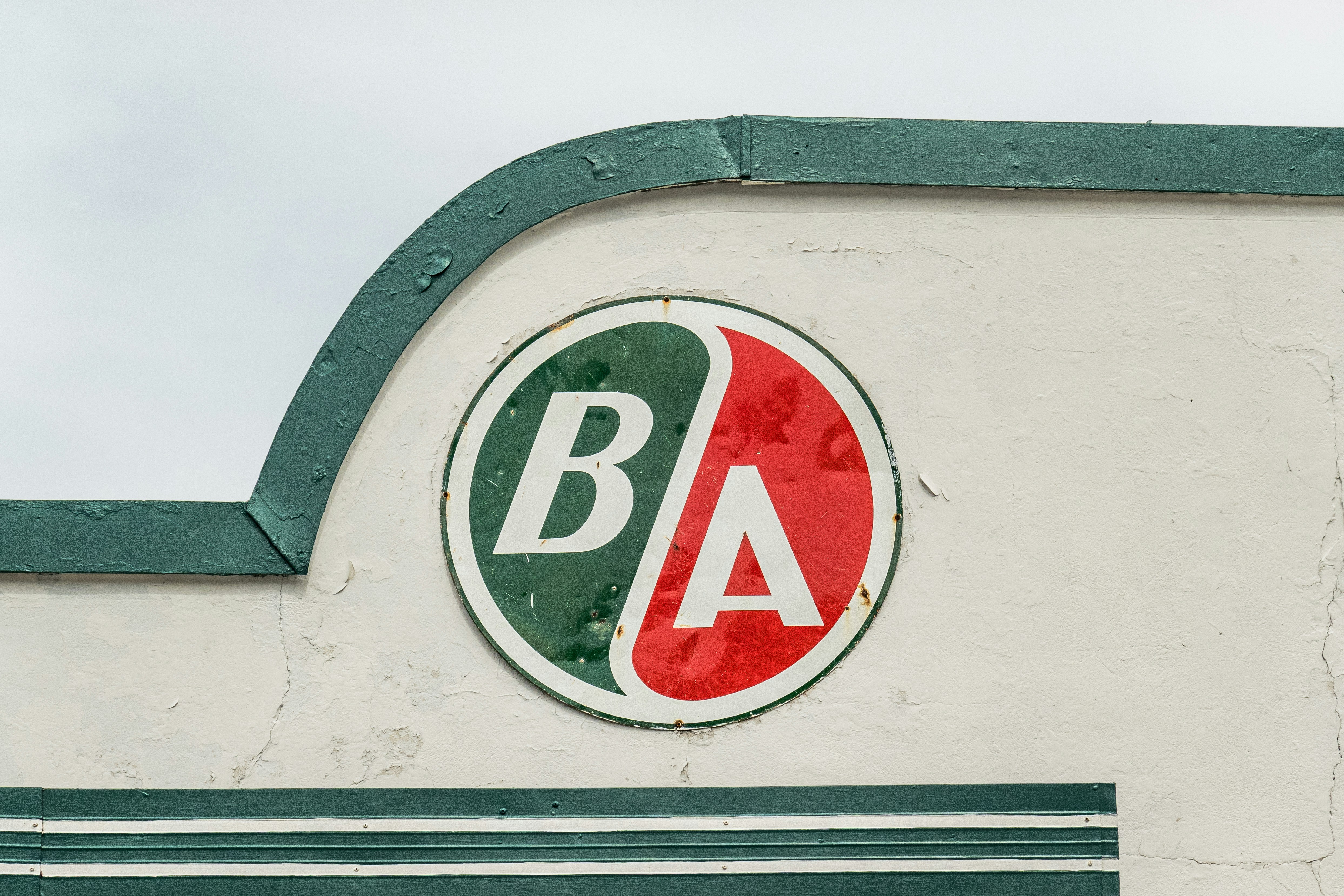 Uma placa circular com as letras BA em uma parede branca