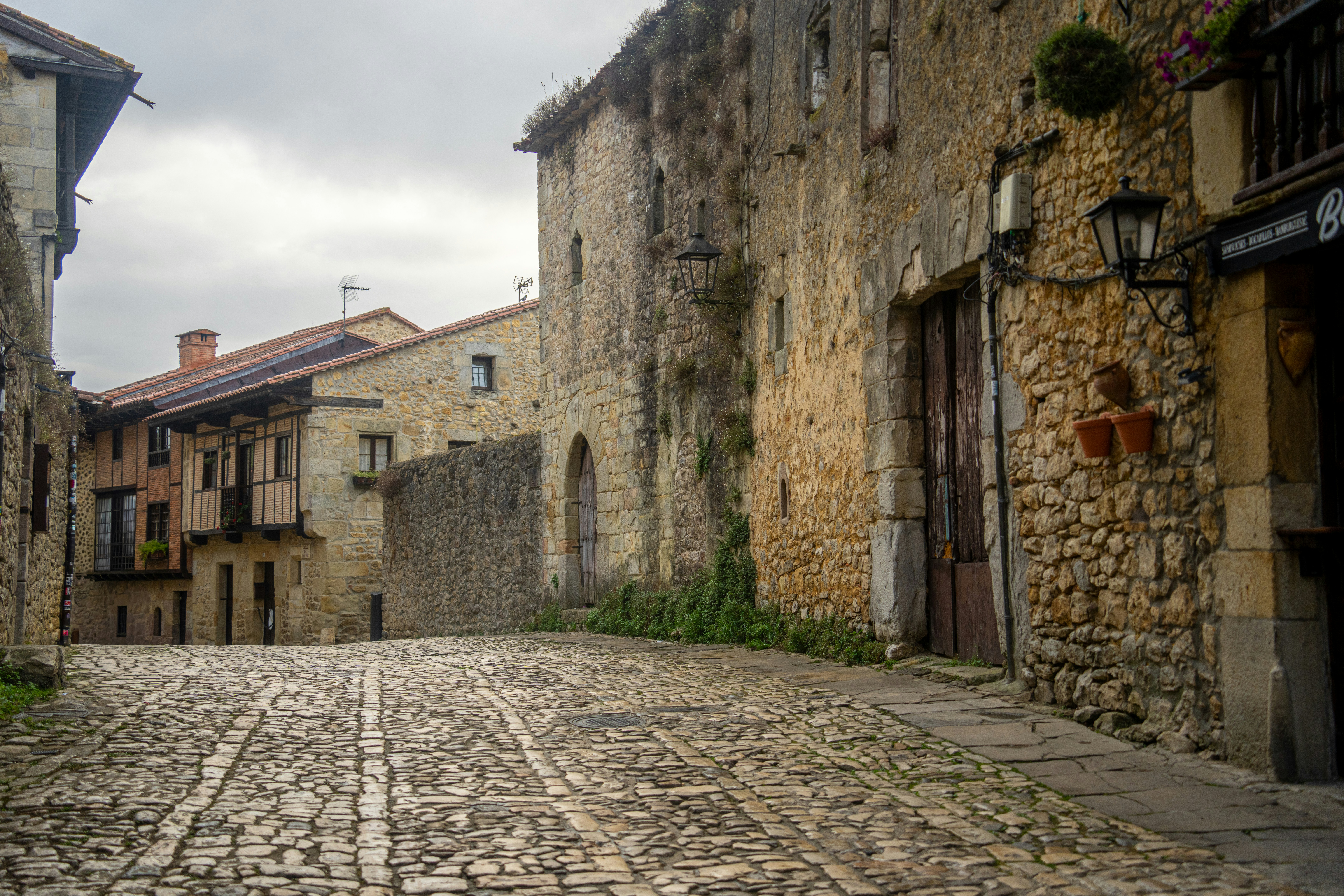 A narrow cobbled street lined with rustic stone houses