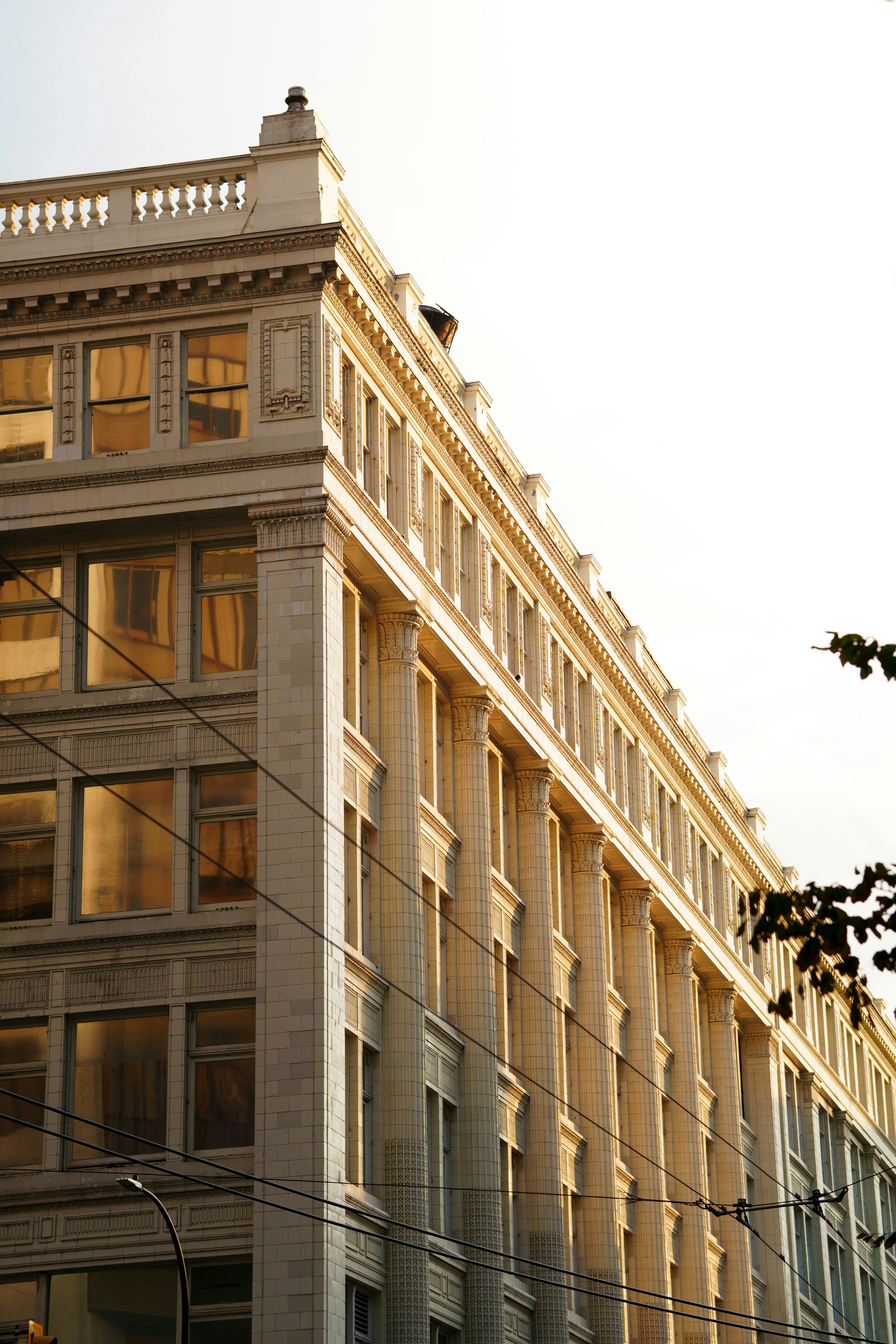 A neoclassical building with white tiled facade and columns in warm golden light