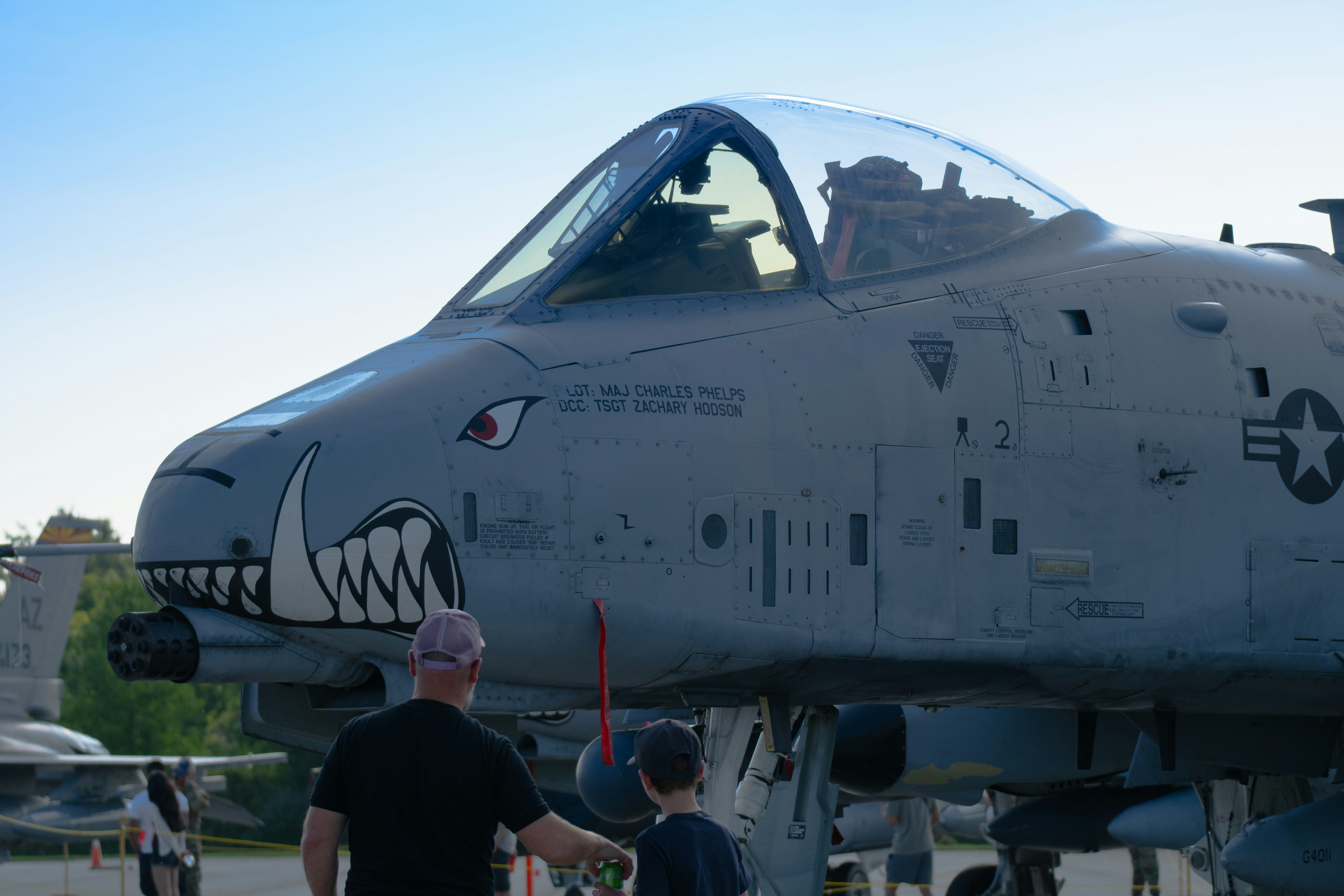 An adult and a child looking at a grey A-10 Thunderbolt II aircraft