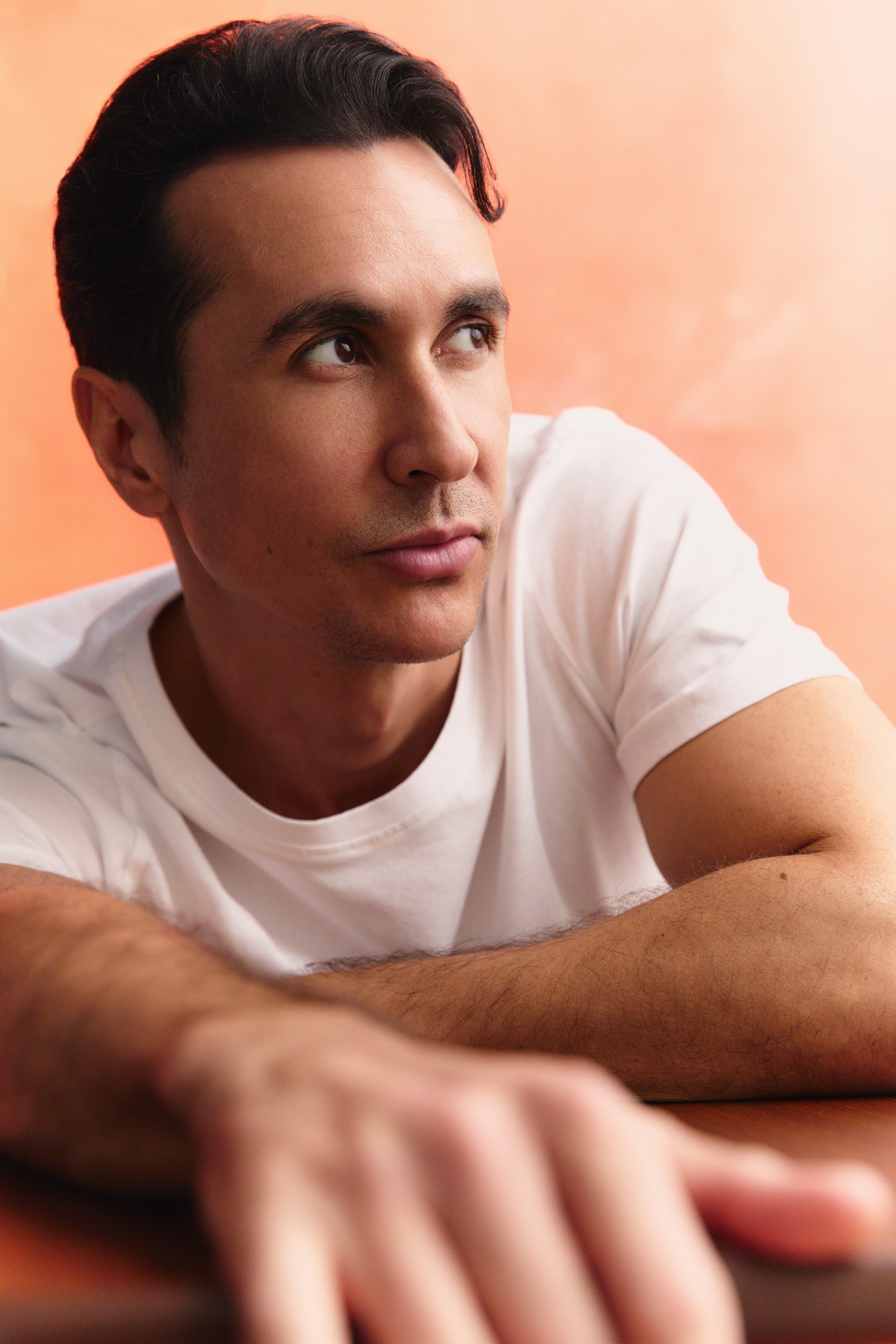 Close portrait in a white T-shirt, leaning on one arm