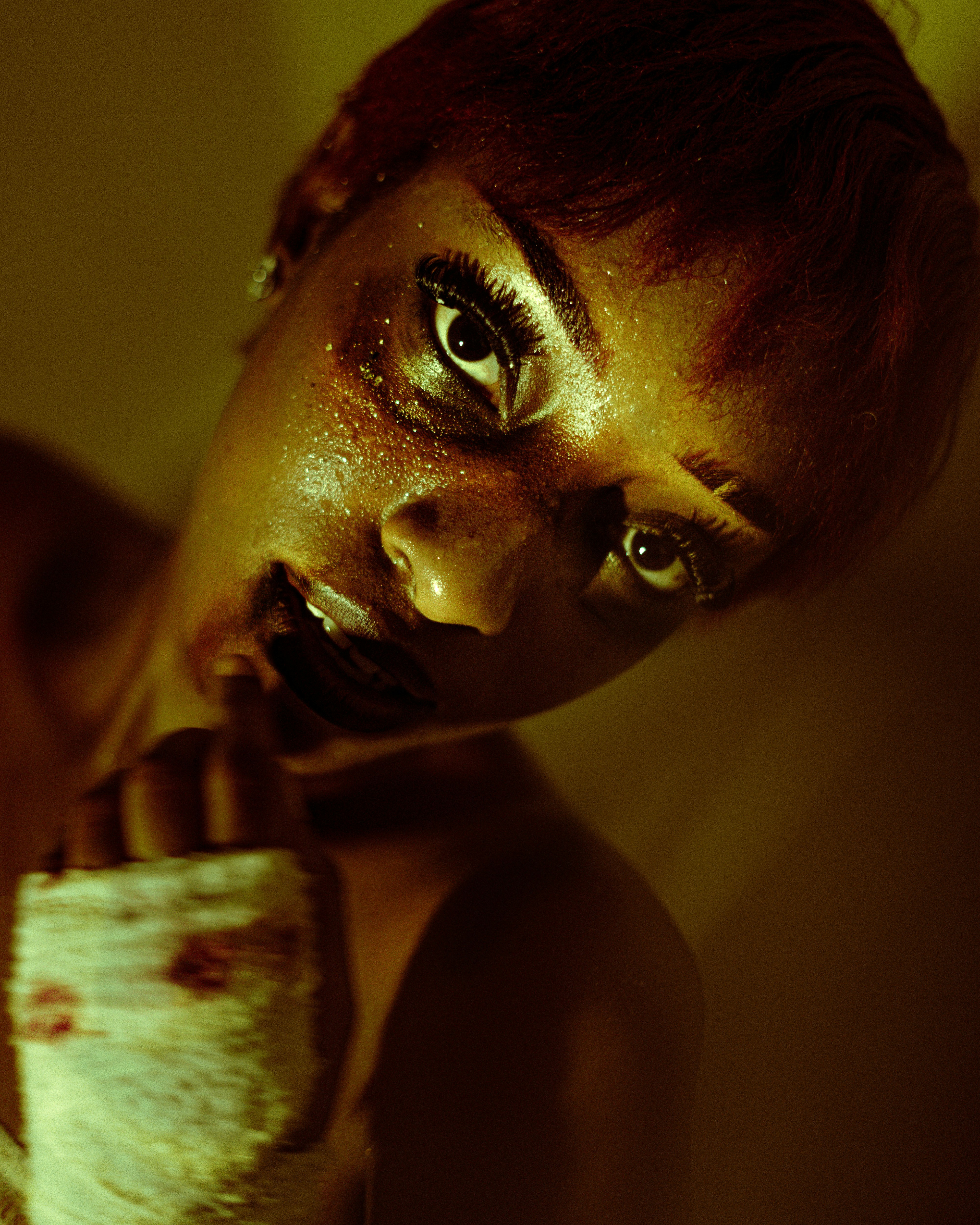 A woman with glitter on her face and a hand wrapped in gauze