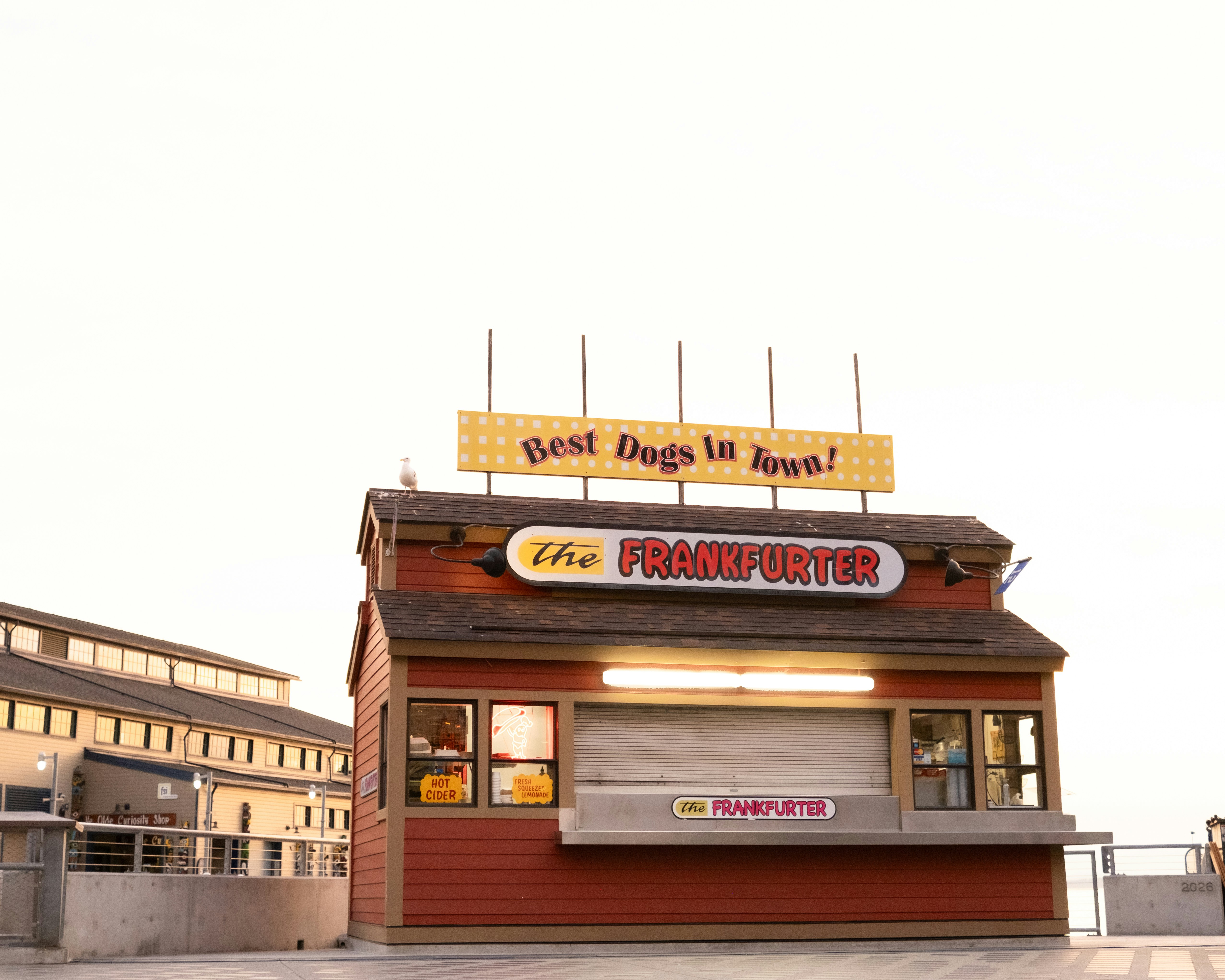 Un stand de nourriture rouge avec un panneau indiquant « le FRANKFURTER » sur une jetée