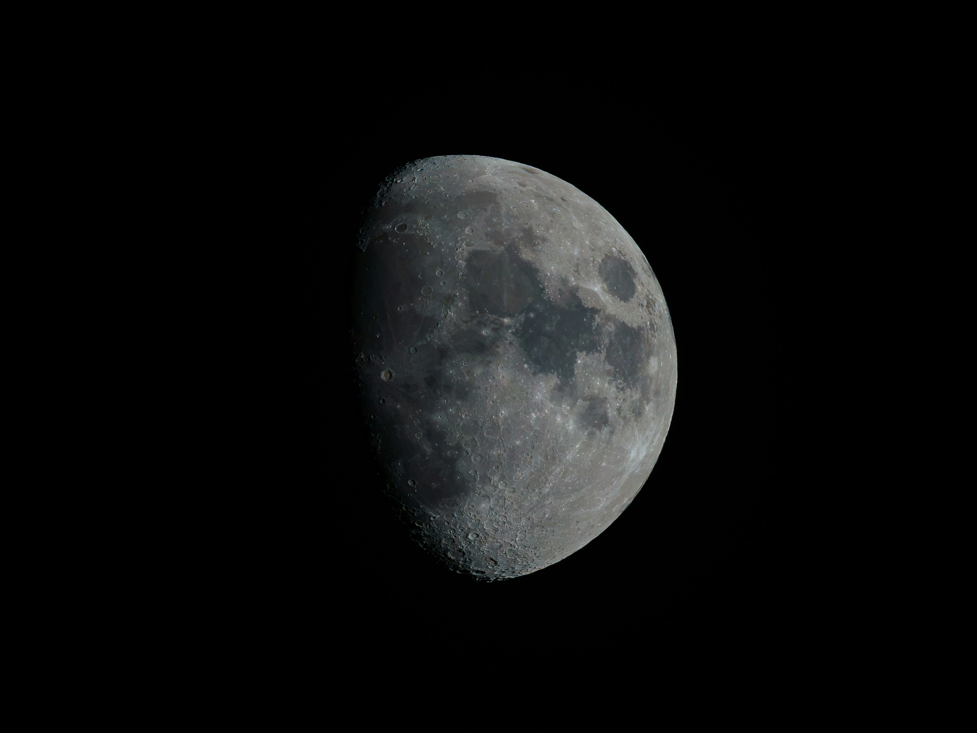 A waxing gibbous moon with visible craters against a deep black sky