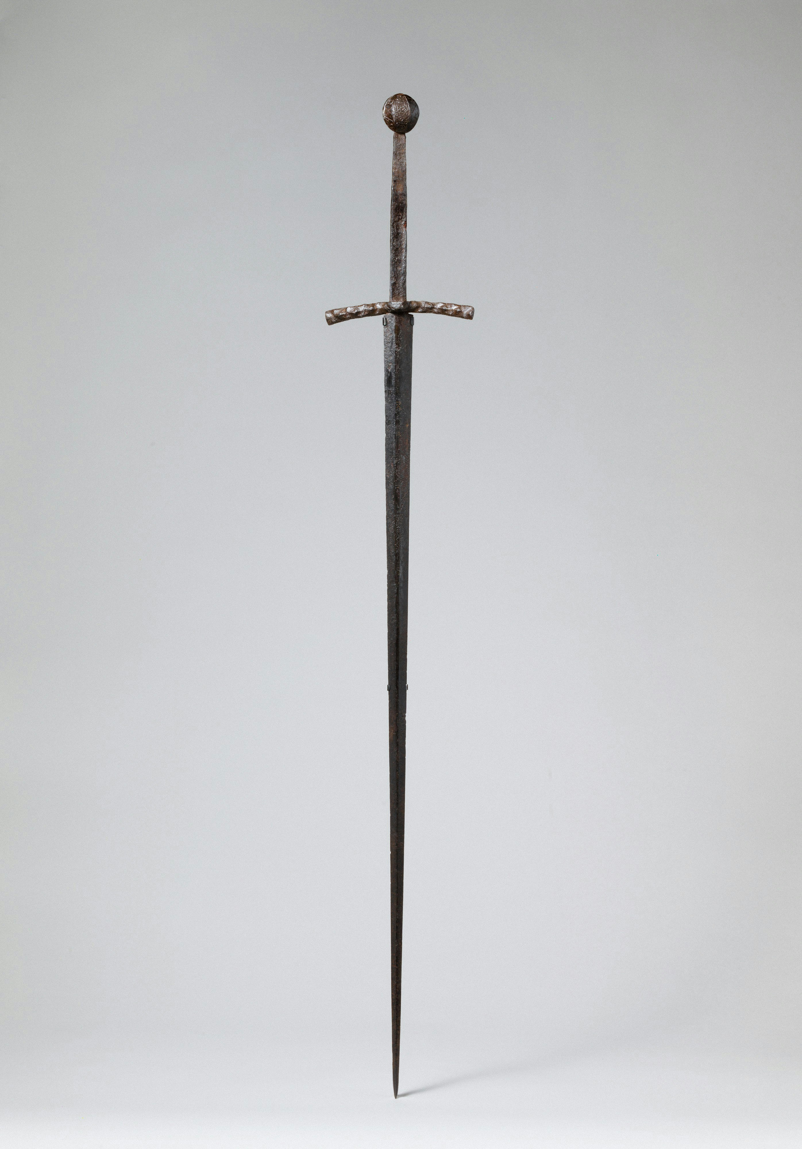 A medieval iron sword with a cross guard and a round pommel