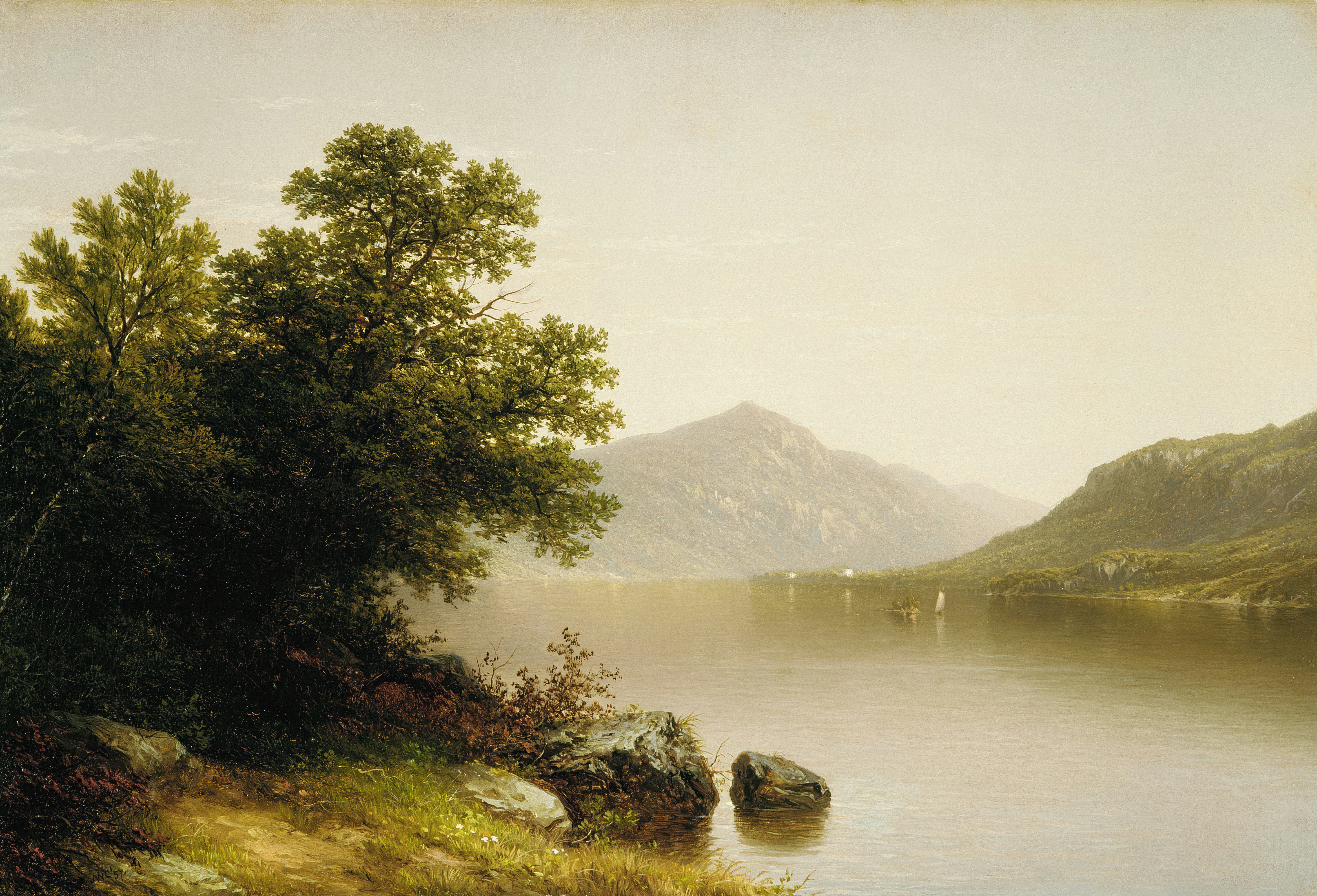 A calm lake reflecting mountains under a hazy sky with a small sailboat