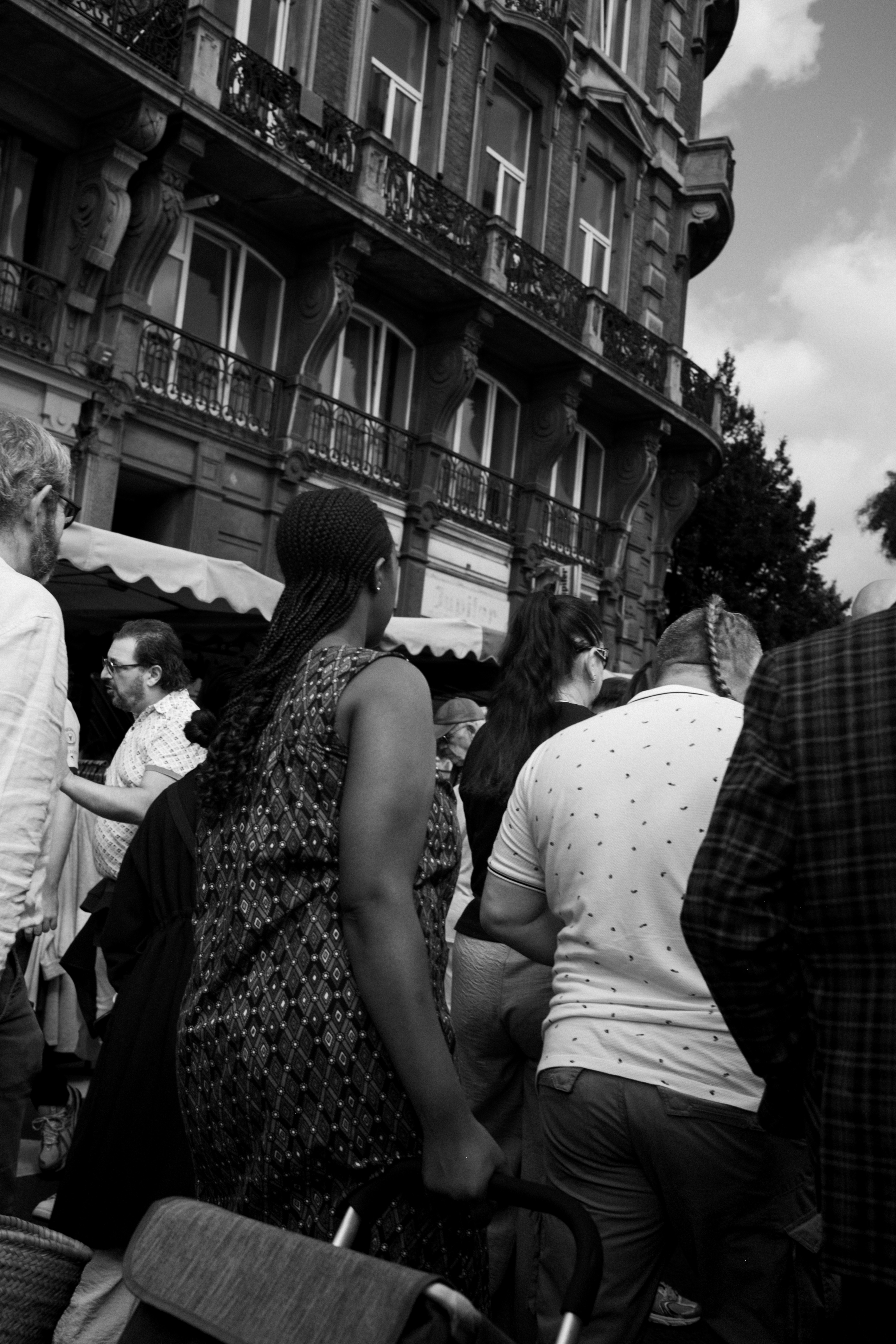 A group of people walking past a historic building on a city street