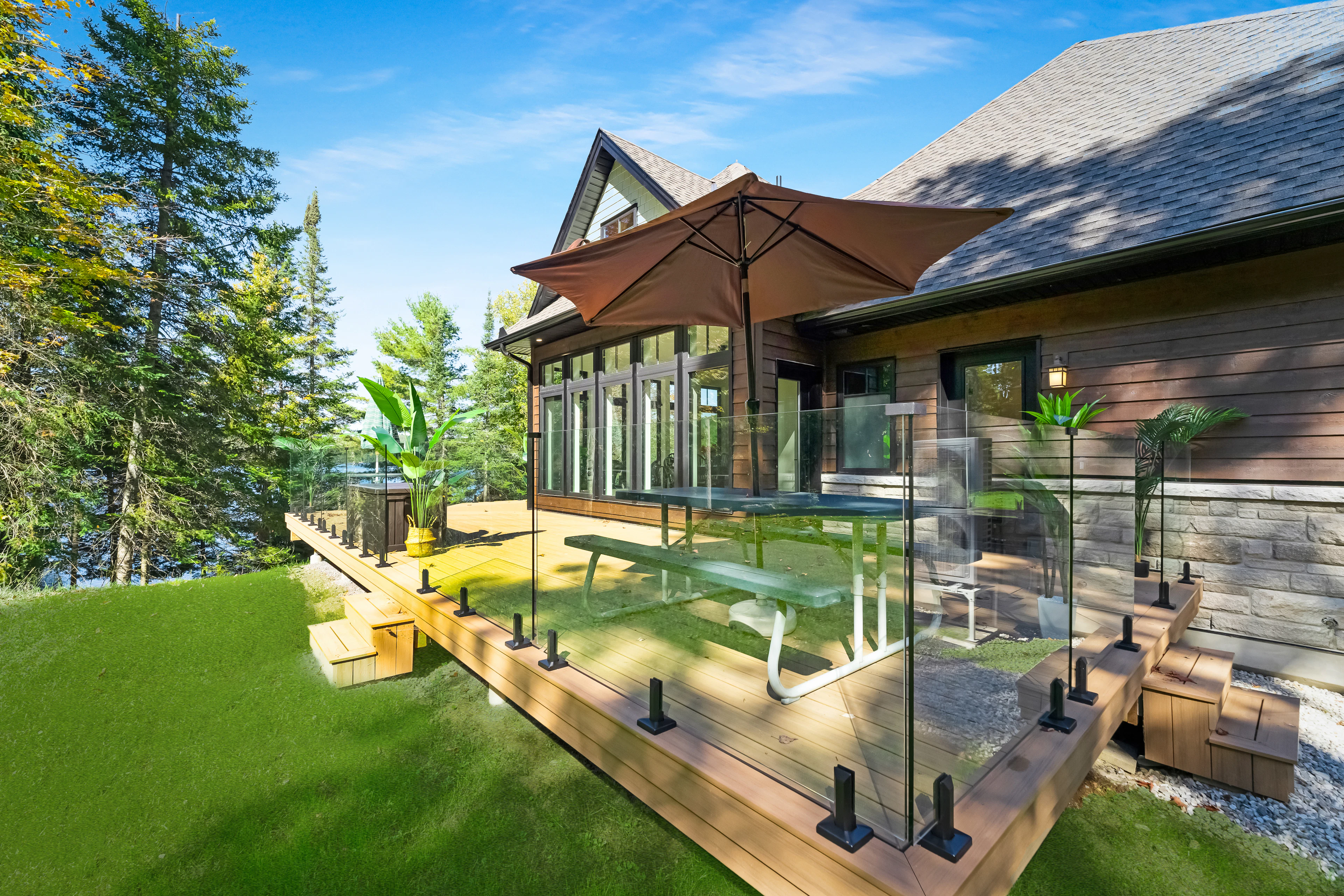 Wooden deck with a glass railing and umbrella