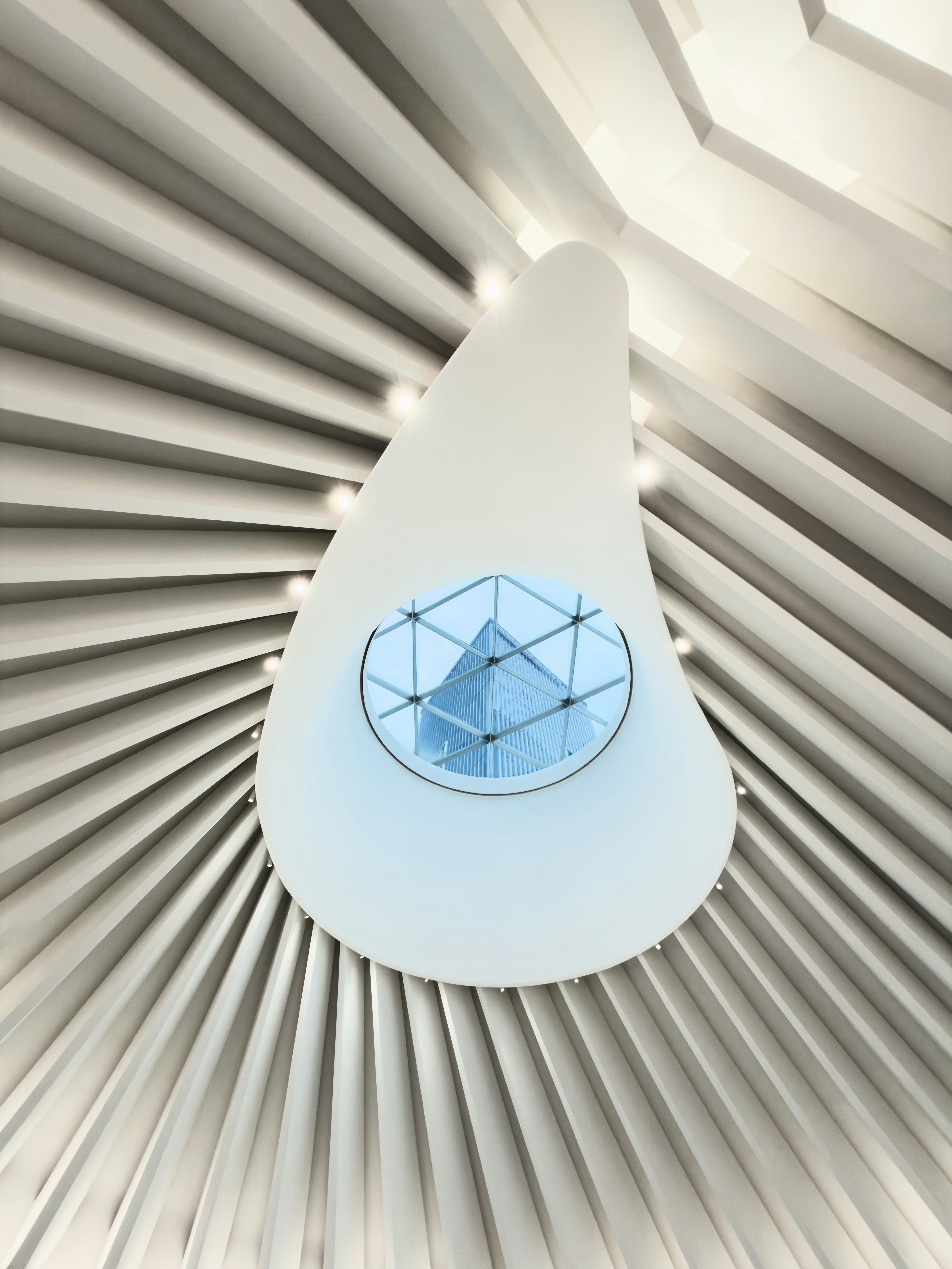 A teardrop shaped skylight with a glass dome reflecting a tall building