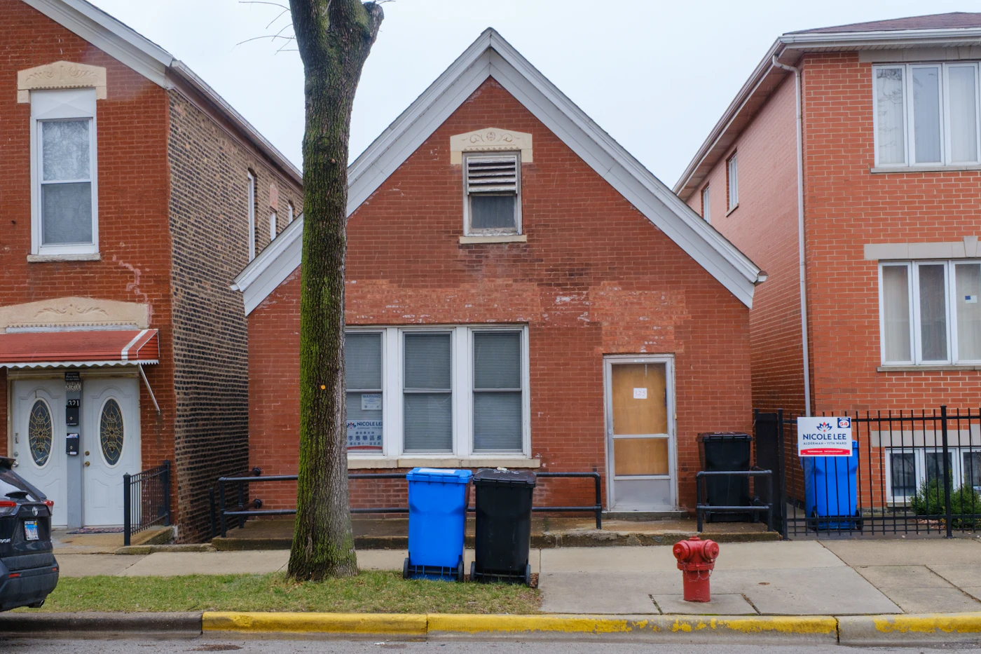 Red brick house with a white door on a city street