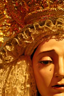 Close-up of a statue face with lace headpiece and gold crown