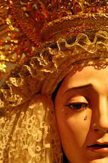 Close-up of a statue face with lace headpiece and gold crown