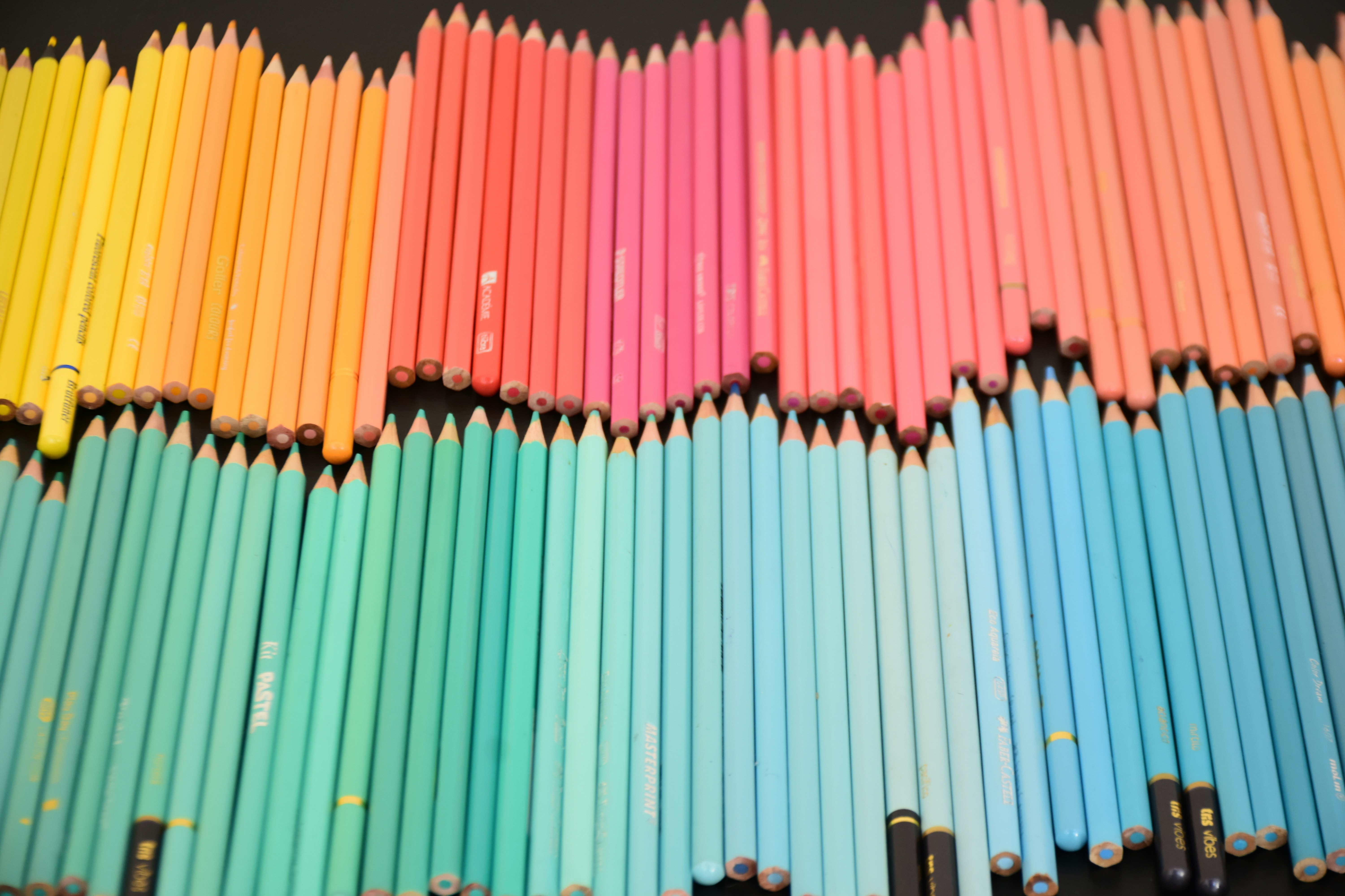 Une grande collection de crayons de couleur disposés en dégradé allant du jaune au bleu
