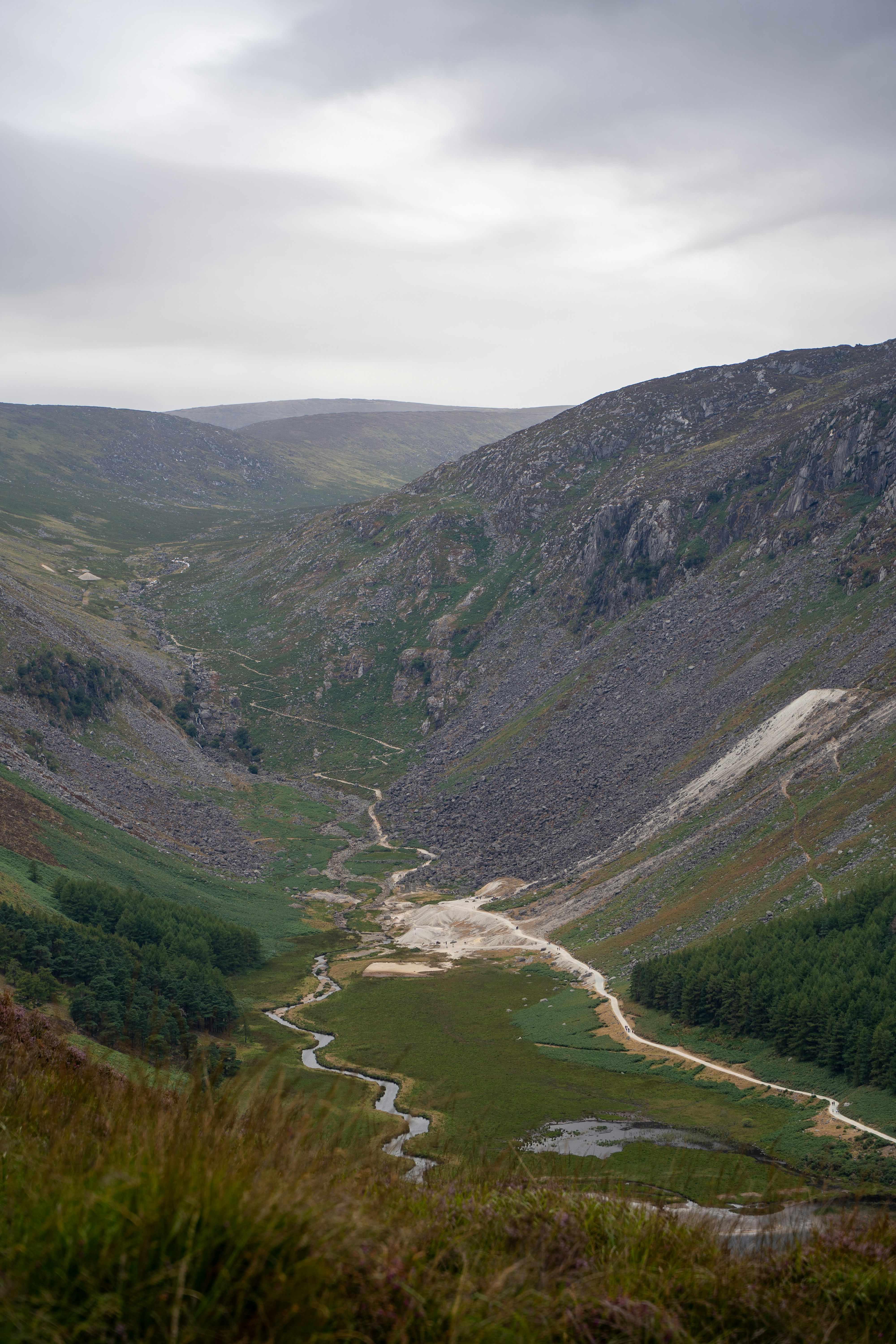 A winding path through a rocky glacial valley with a small stream
