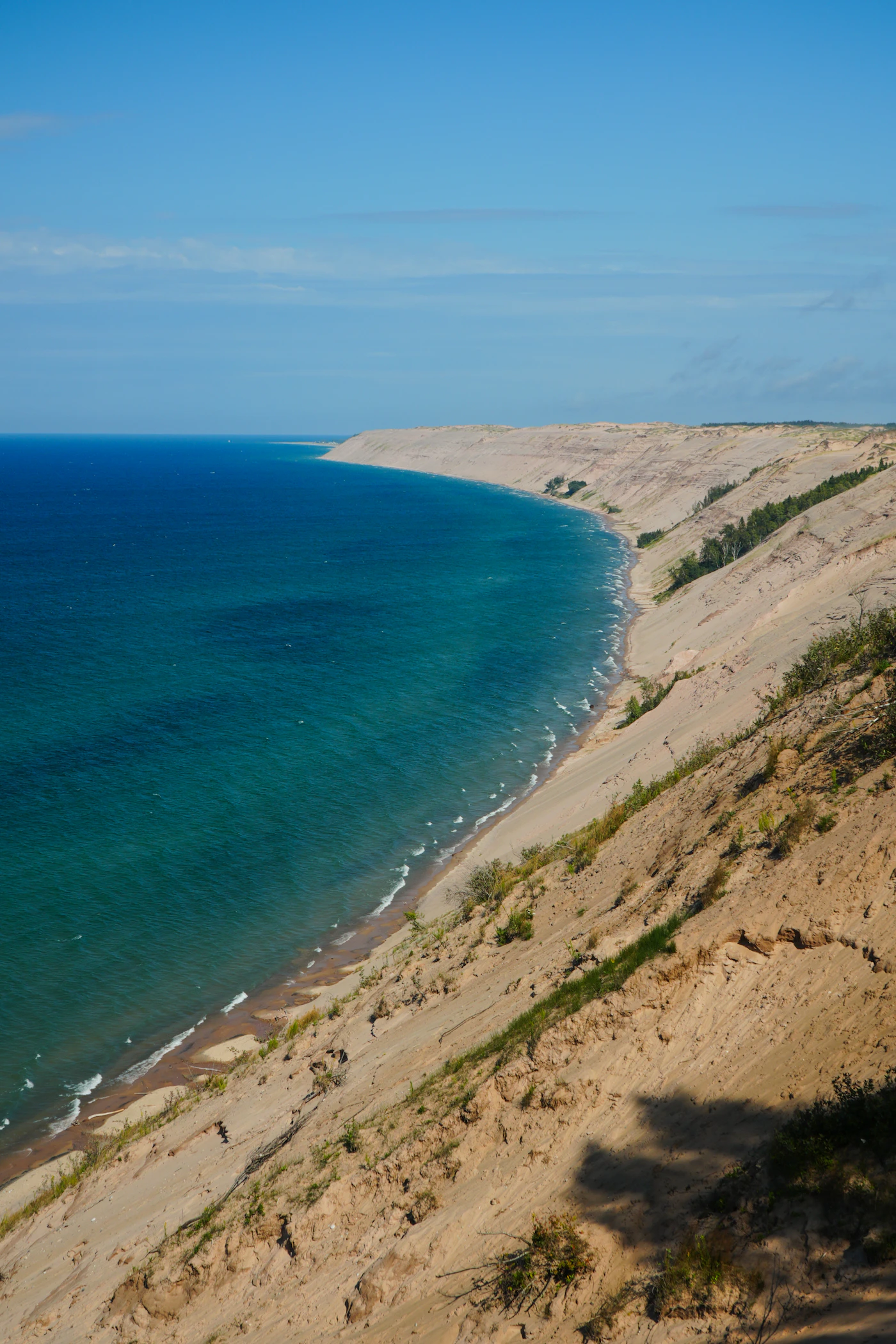 Steep sandy bluff dropping to the blue water of Lake Michigan, the dune landscape around Sleeping Bear