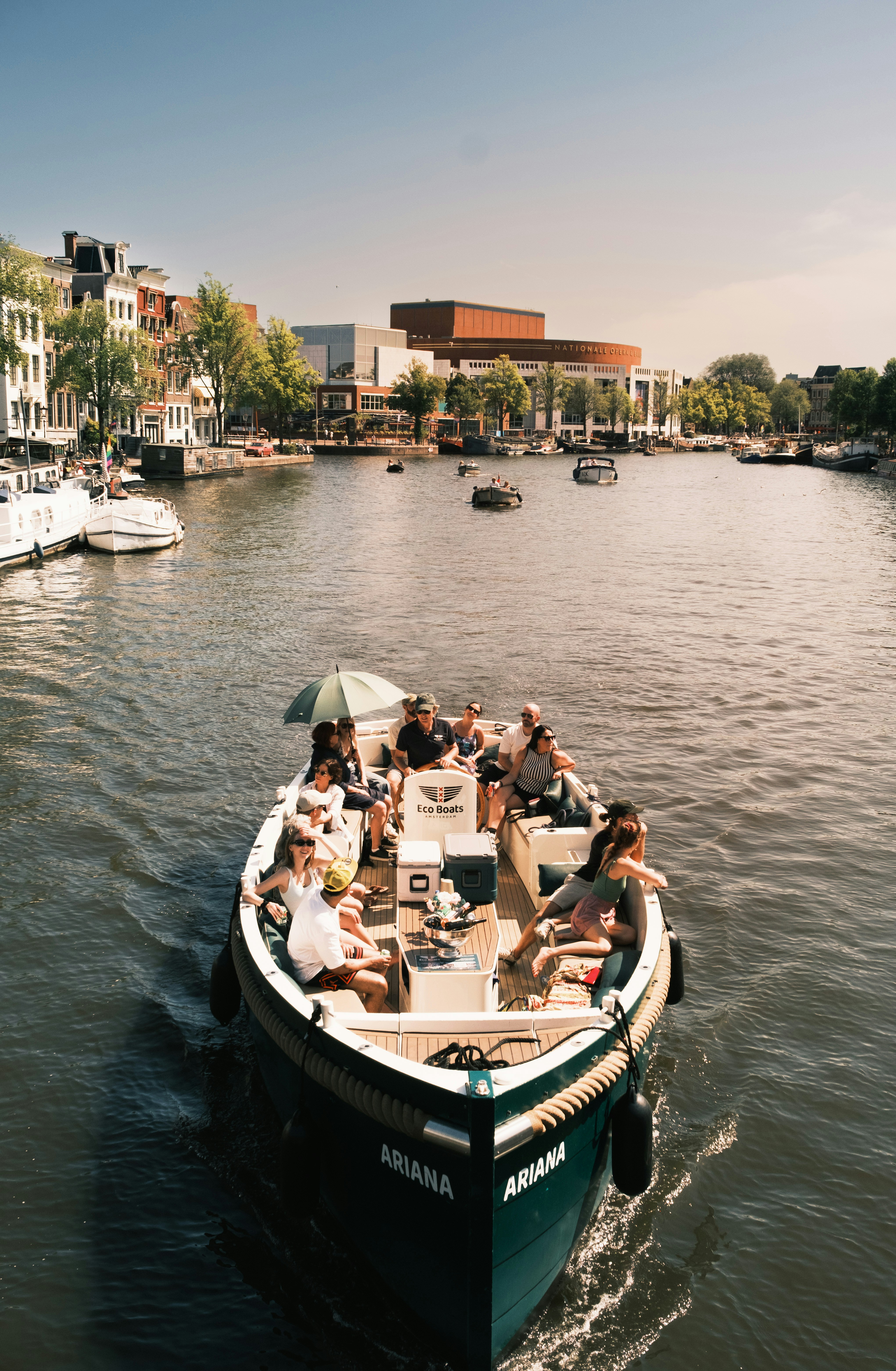 A group of people on a boat cruising along a canal in Amsterdam