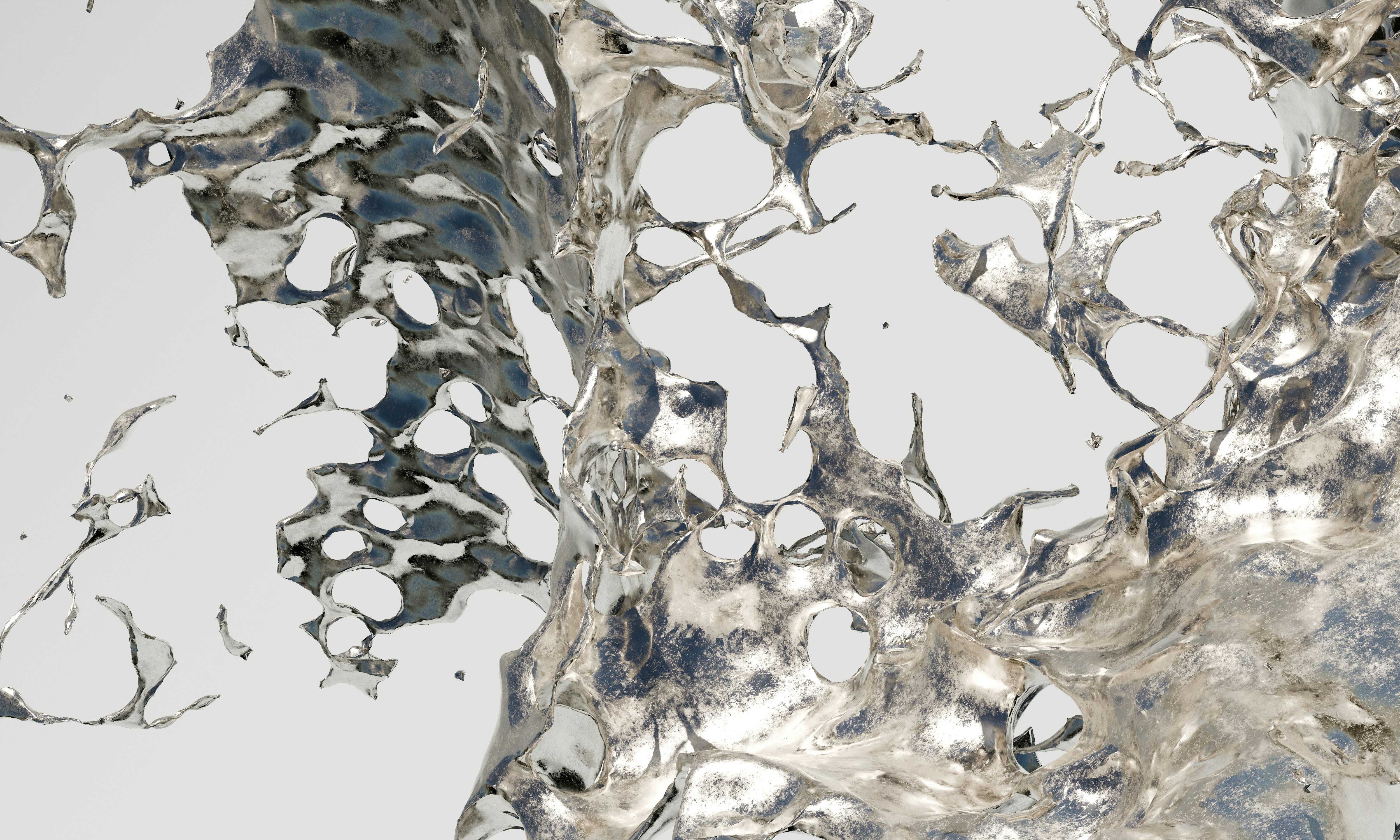 A splash of liquid silver against a plain light grey background