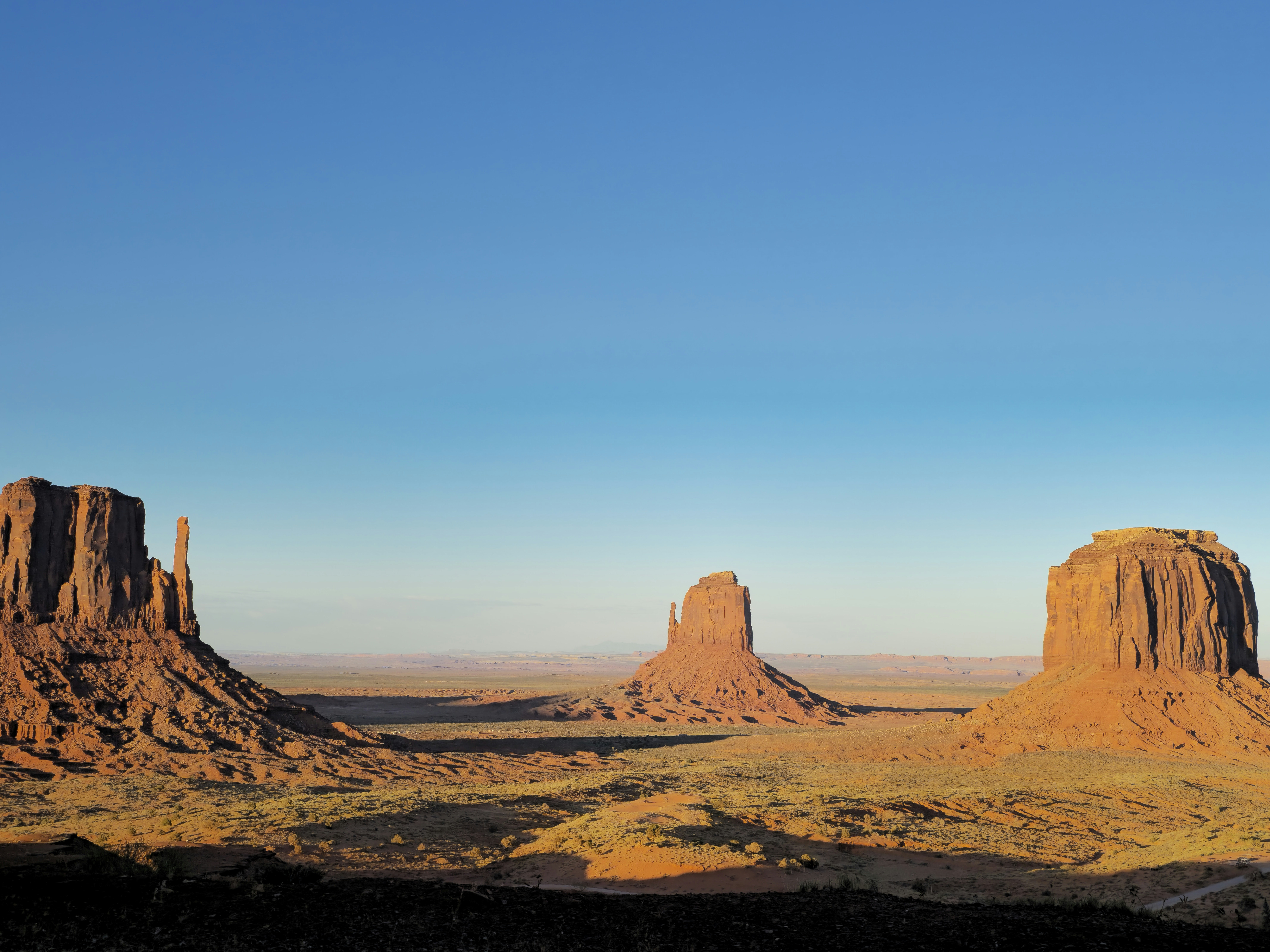 Monument Valley sandstone buttes under a blue sky
