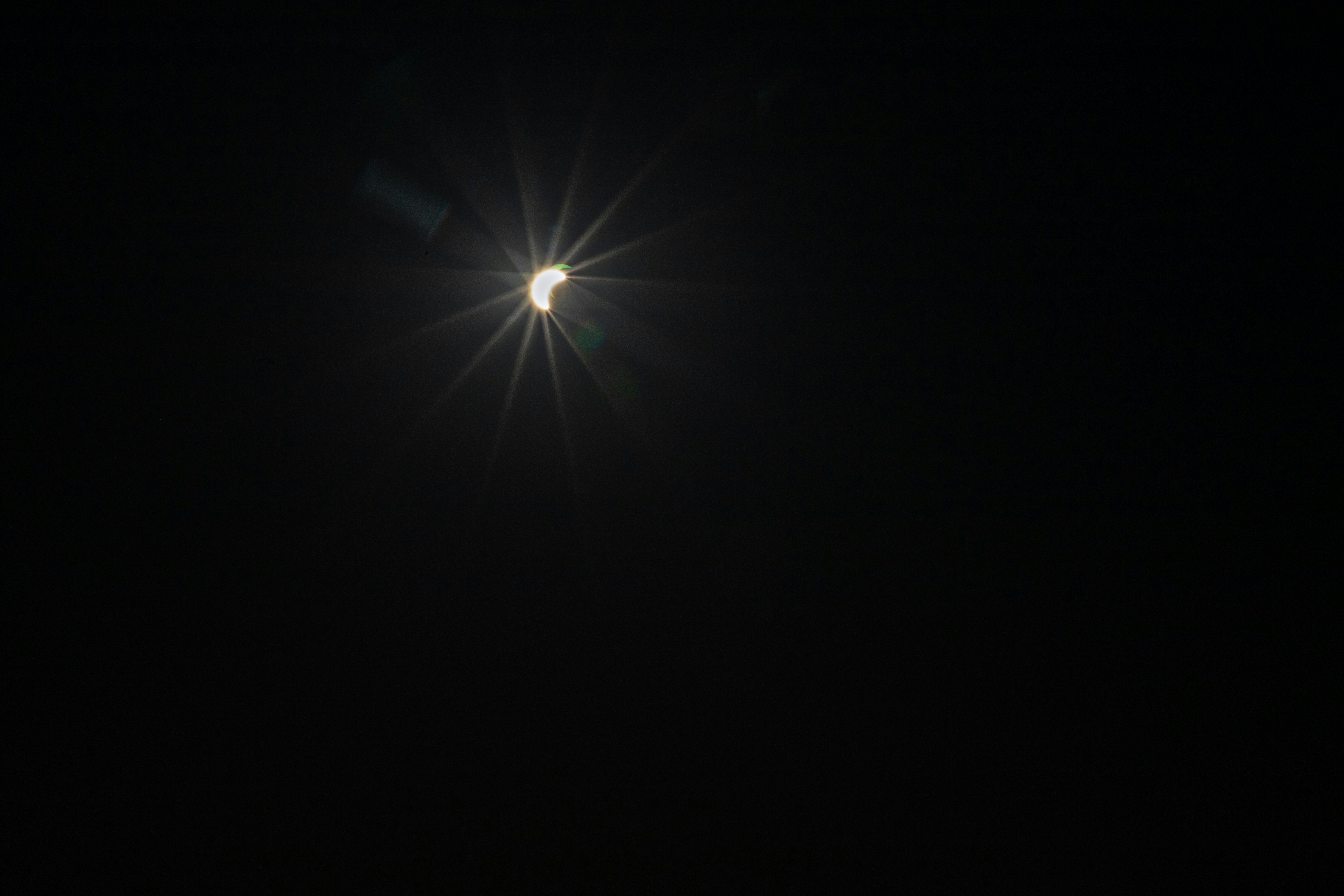 Un'eclissi solare parziale con un effetto stellare brillante contro un cielo nero