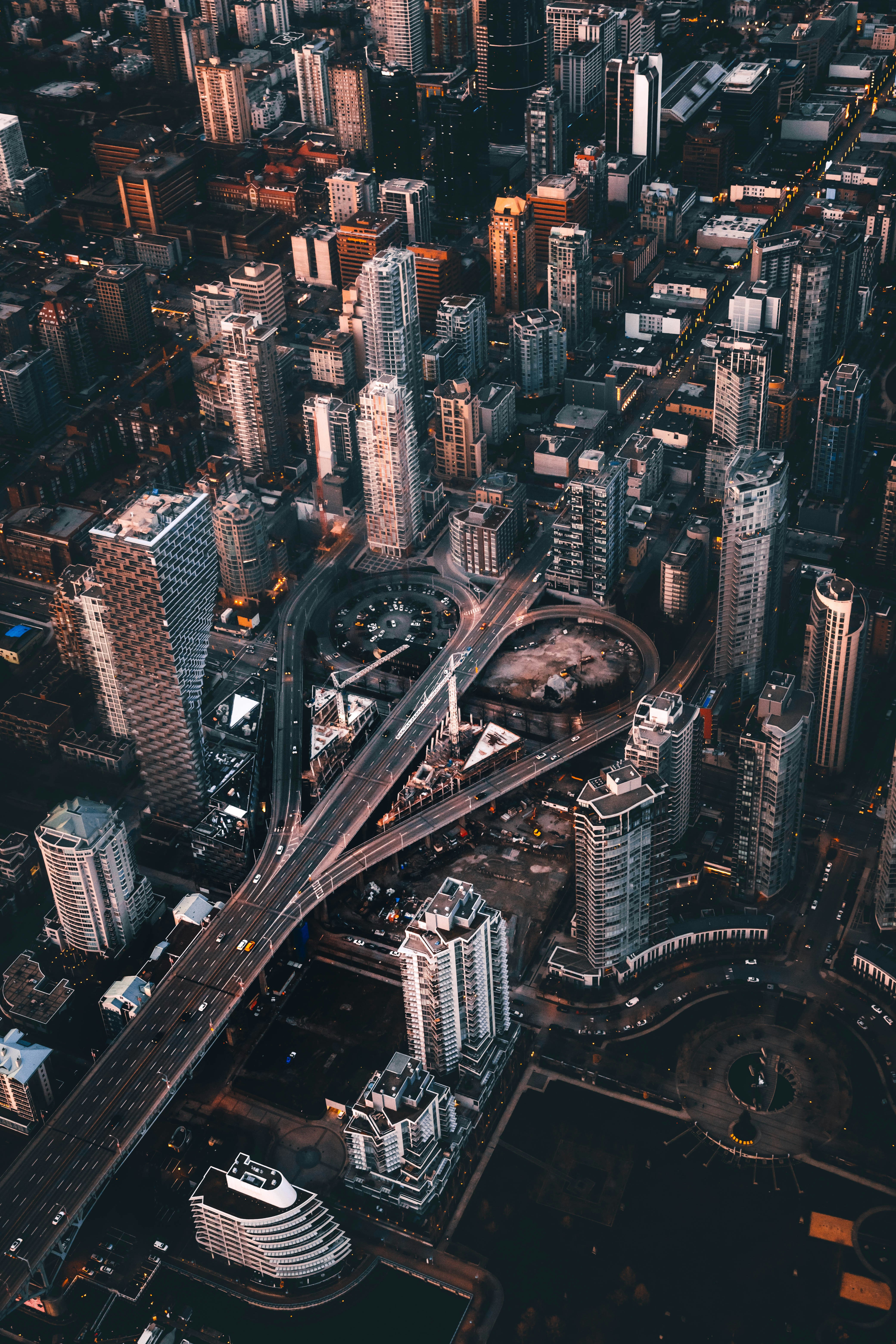 An aerial view of skyscrapers and a highway interchange in Vancouver at golden hour