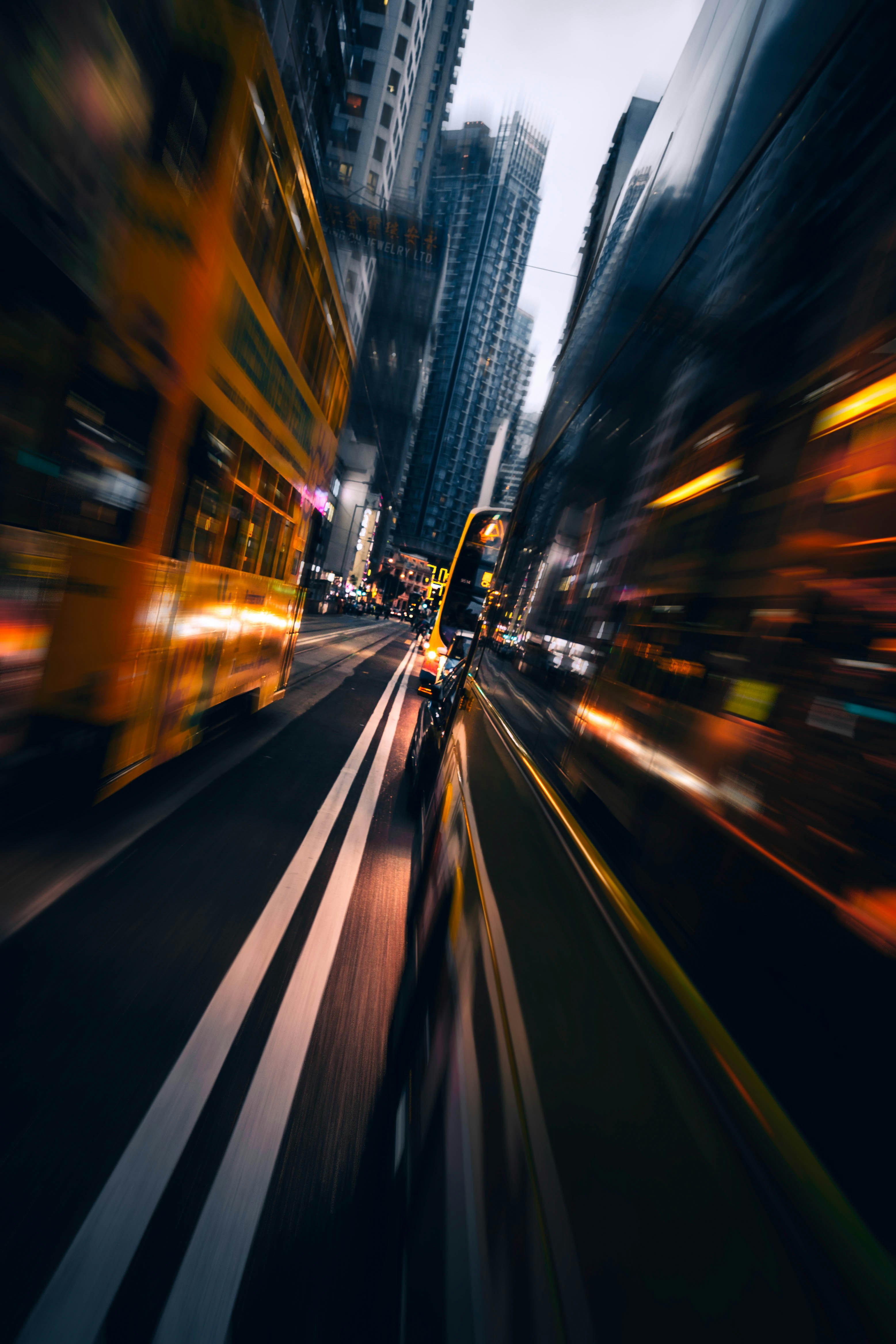 A yellow double-decker tram moving through a city street with motion blur