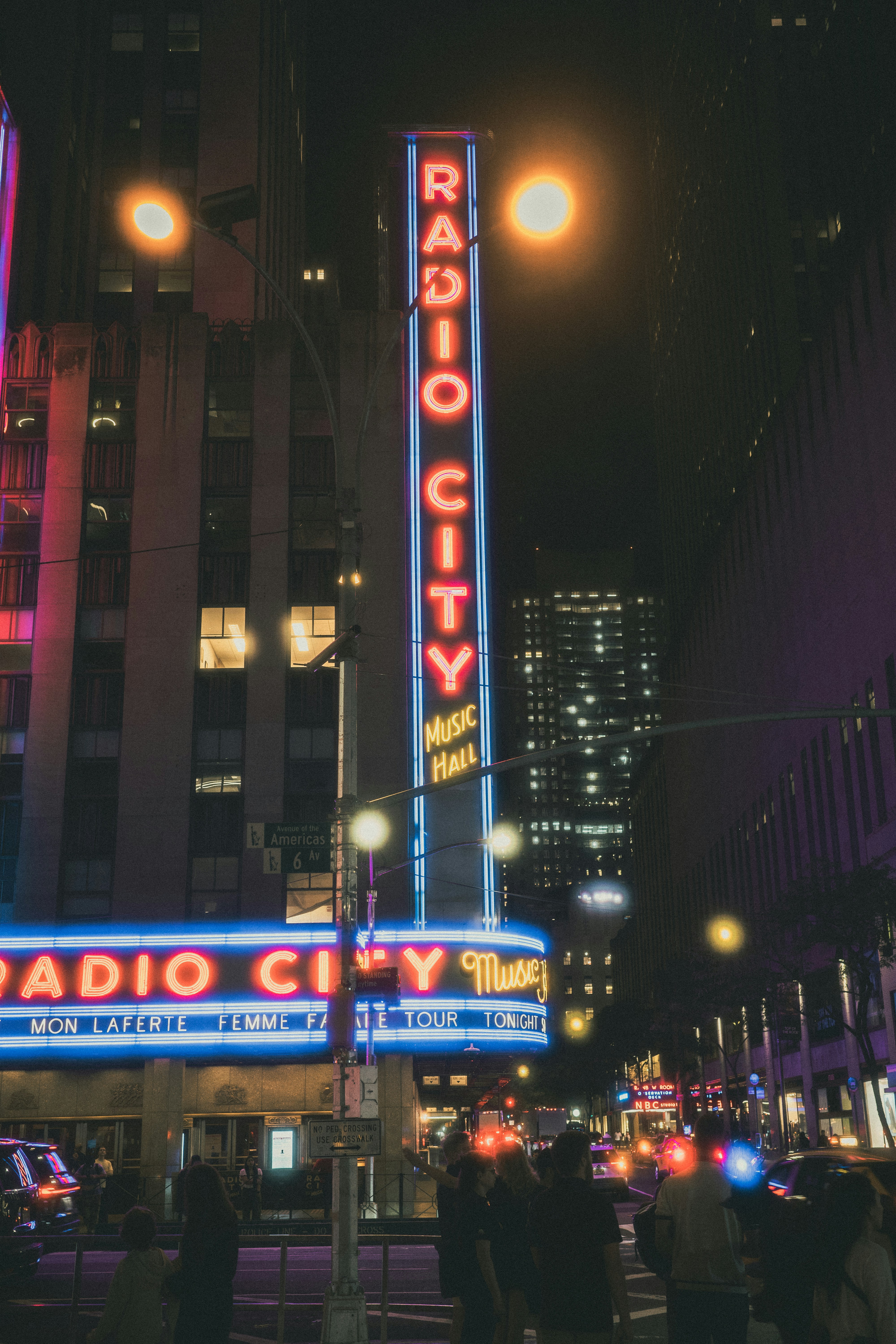 The neon Radio City Music Hall sign glowing above a busy New York street