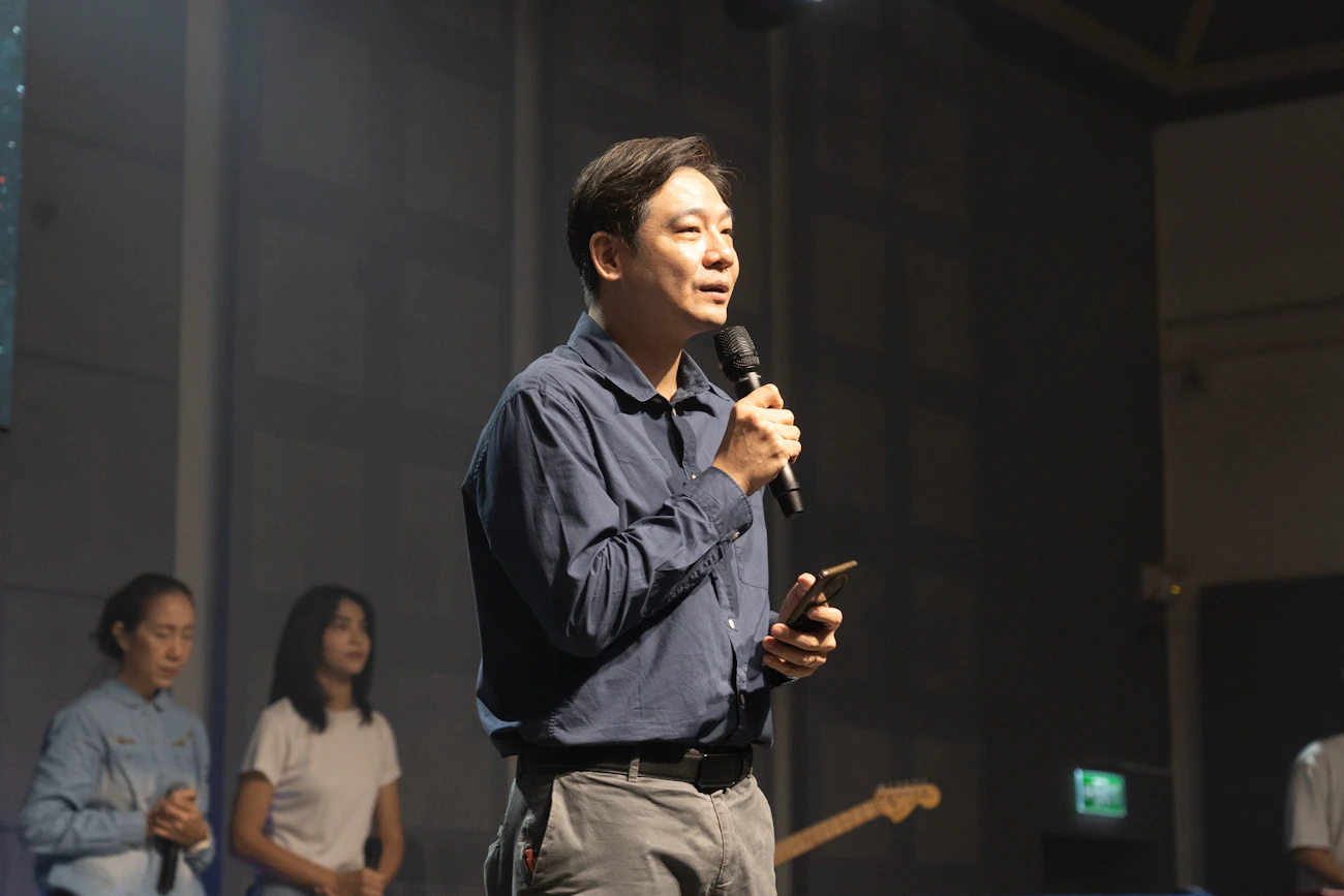 무대에서 마이크를 들고 강연하는 연자