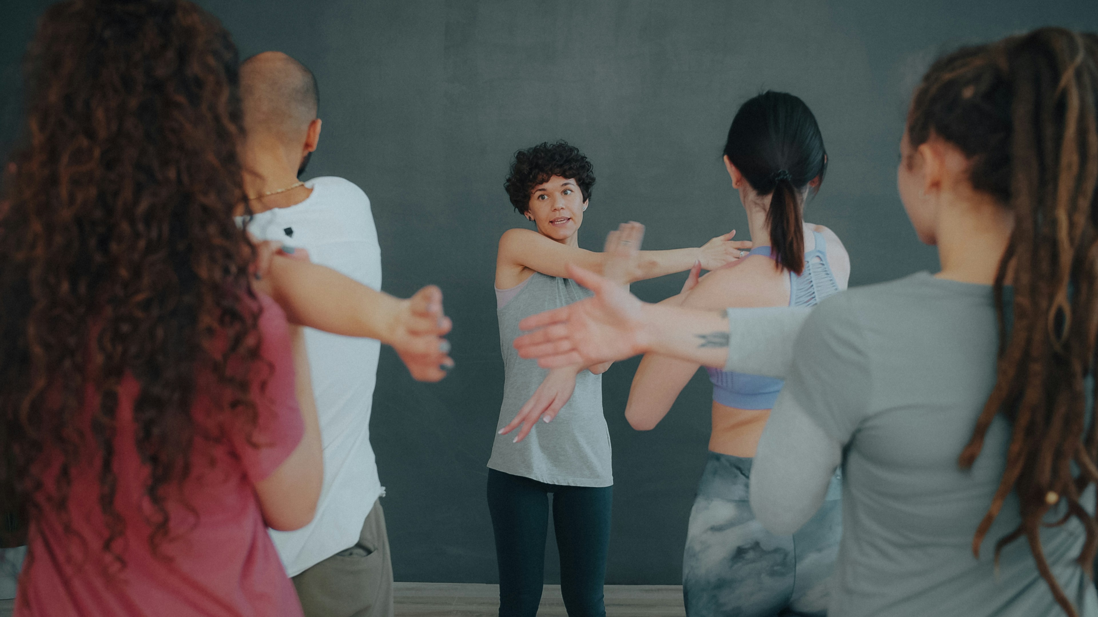 A group of people stretching their arms in a fitness class
