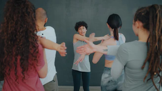 A group of people stretching their arms in a fitness class