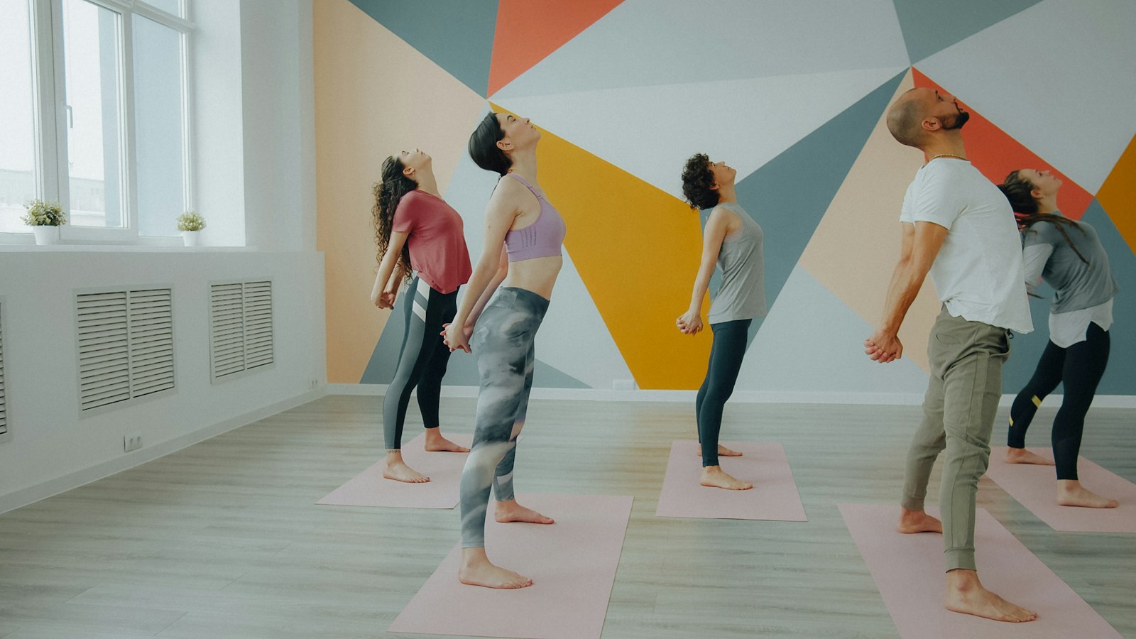 Un cours de yoga dans un studio lumineux aux murs géométriques